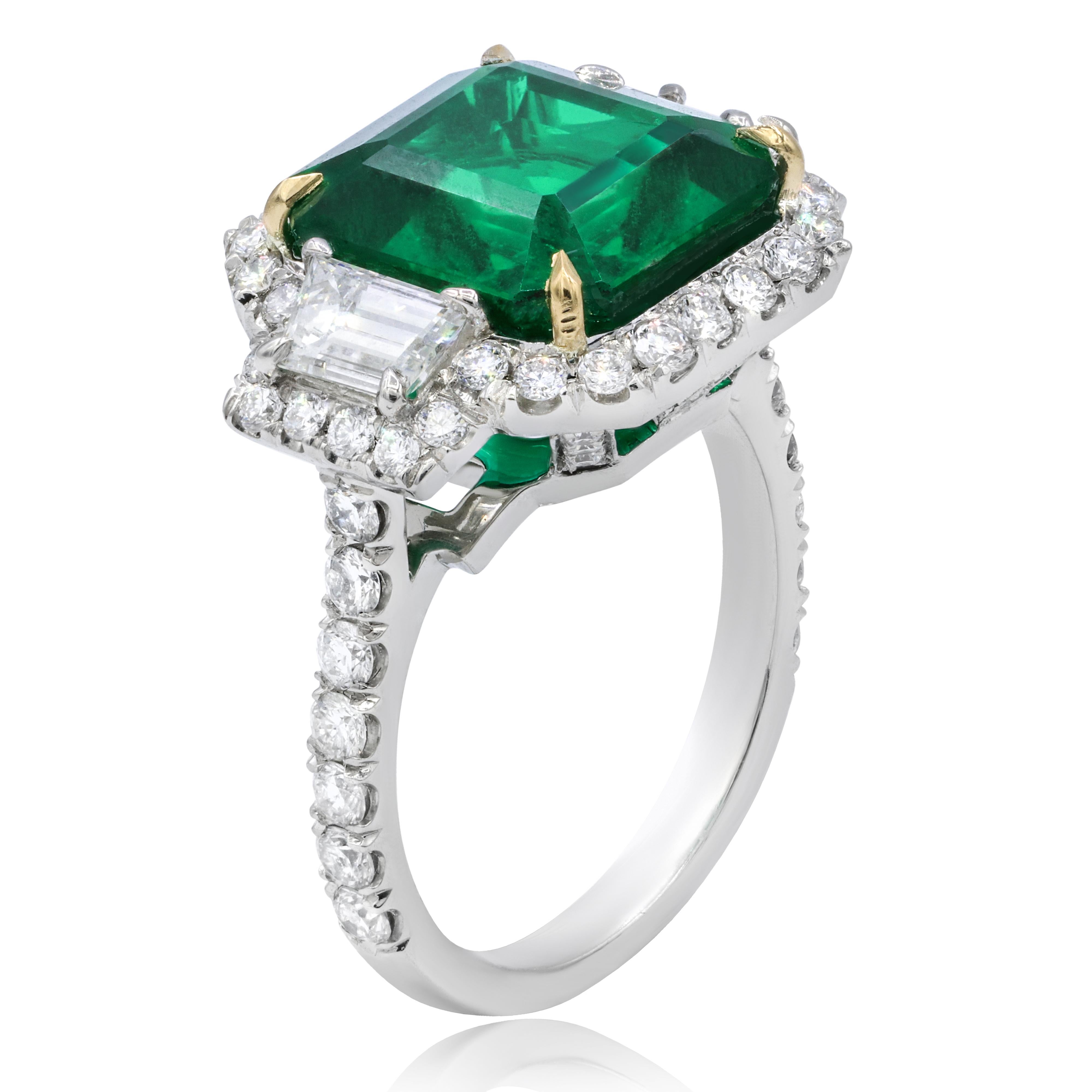 Platinum and 18k yellow gold green emerald ring features 6.67 ct green emerald set with 1.40 cts of baguette diamonds and round diamonds in a halo setting.
Ring size: 6
Can be resized to any finger size.

This product comes with a certificate of