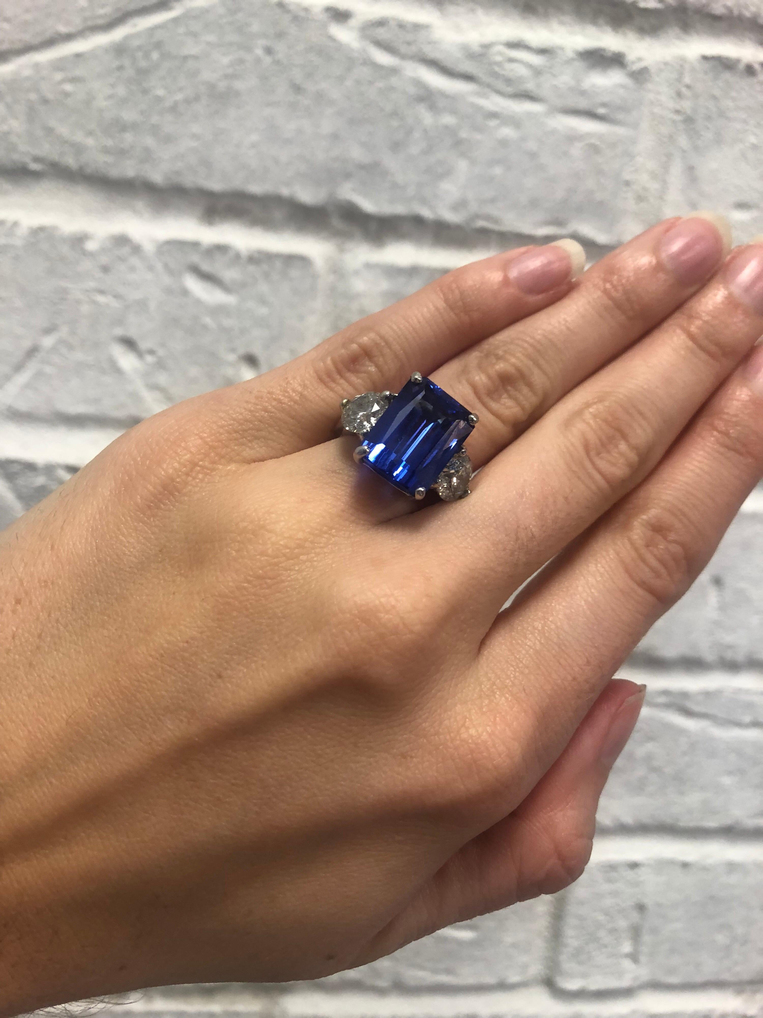 Beautiful platinum 3 stone emerald cut tanzanite and diamond ring. The center Emerald cut tanzanite weighs 7.1ct and the 2 two round brilliant cut diamonds weigh approximately 1.15 and are I-J in color and I2 in clarity. Ring size is 6 and can be