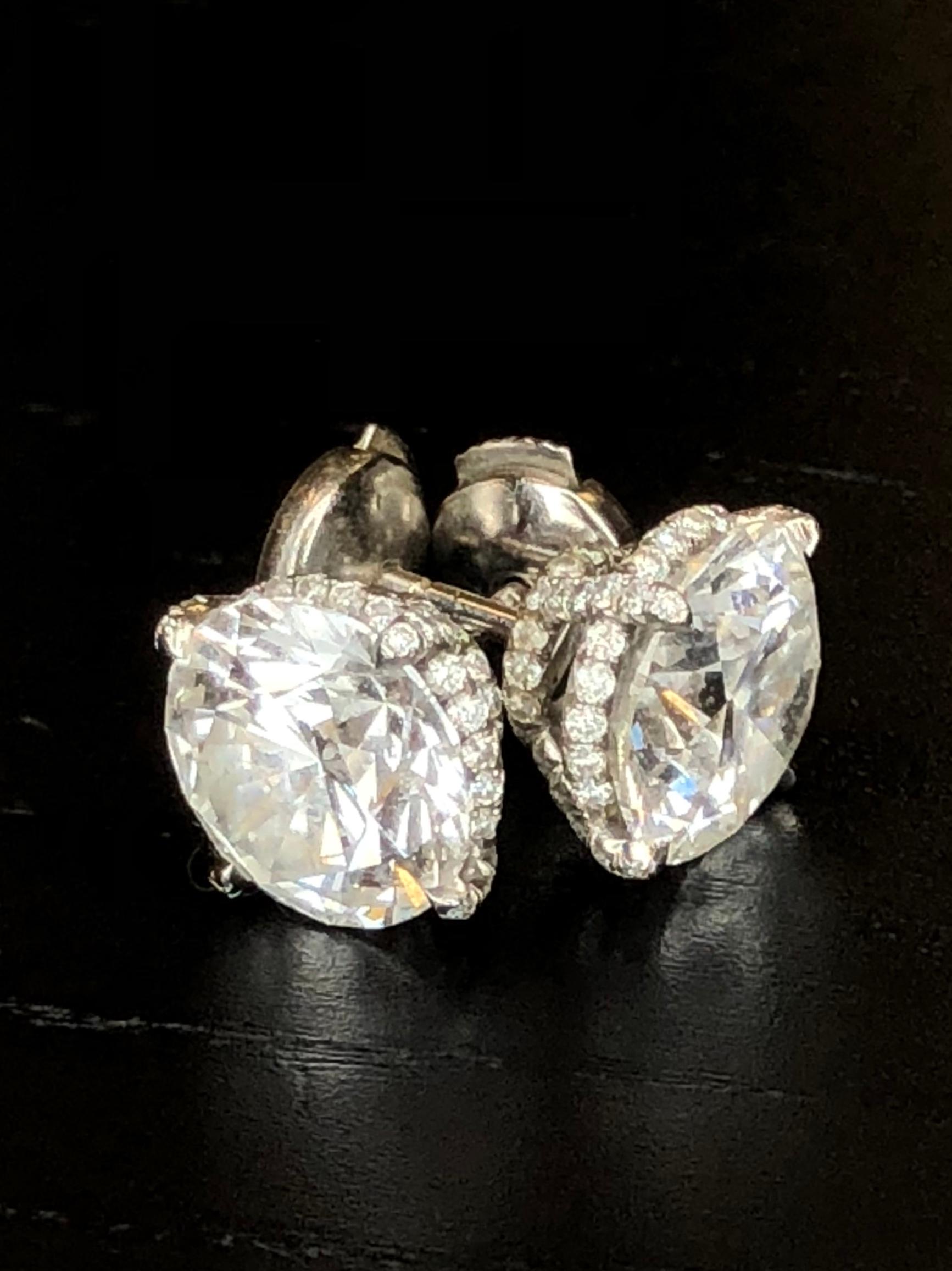 A platinum pair of stud earrings containing two 3.50 ct and 3.51 ct Round Brilliant Diamonds set in a pave diamond four prong setting. 3.50ct G Color VS1 Clarity Triple Excellent Diamond and a 3.51 G Color VS1 Clarity Triple Excellent Diamond for a