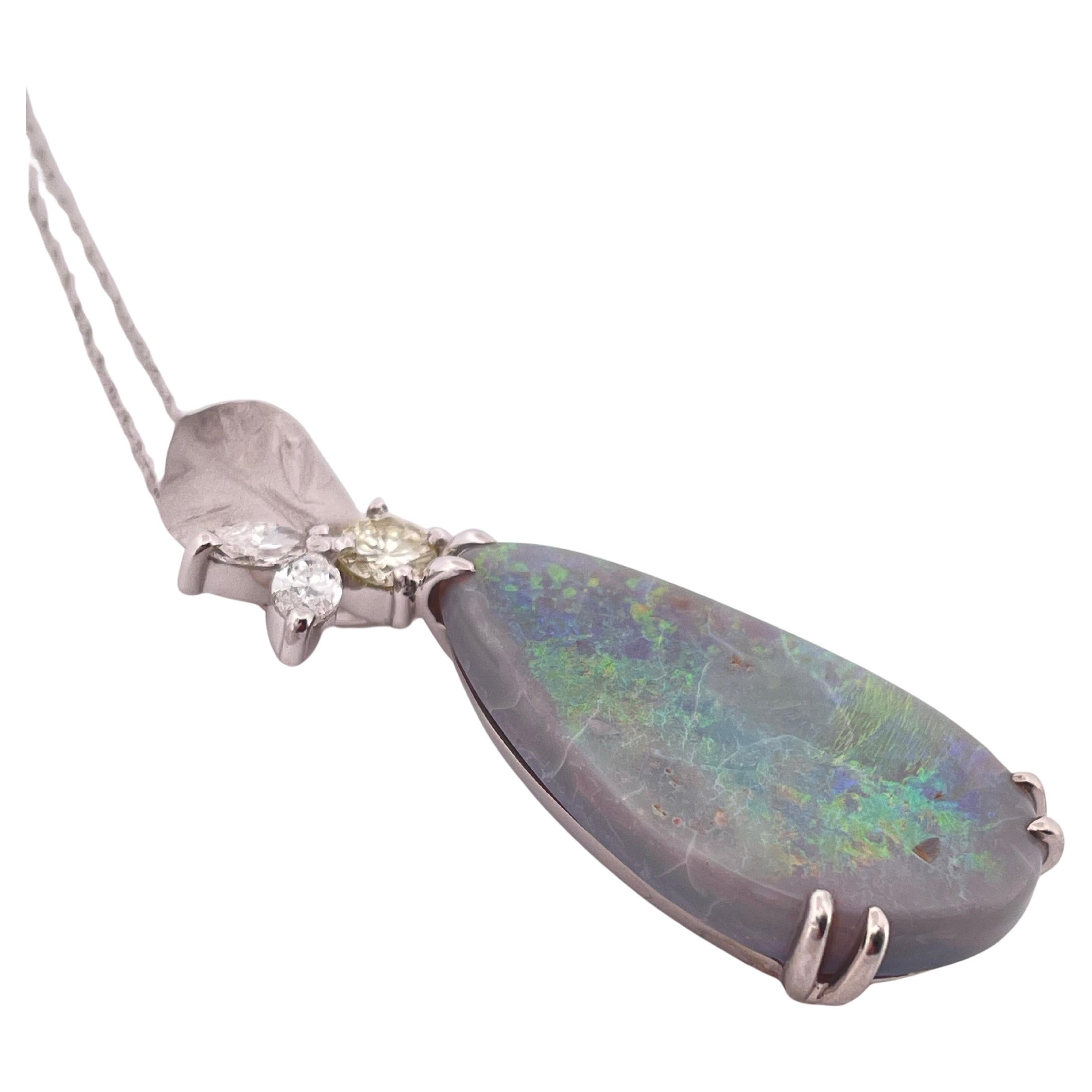 Diese elegante Halskette mit Anhänger präsentiert einen faszinierenden 9,7-karätigen Opal, der mit grünen, blauen und feurigen Reflexen über seine polierte Oberfläche tanzt. Der birnenförmige Opal ist in glänzendes Platin (Pt900) gefasst und wird