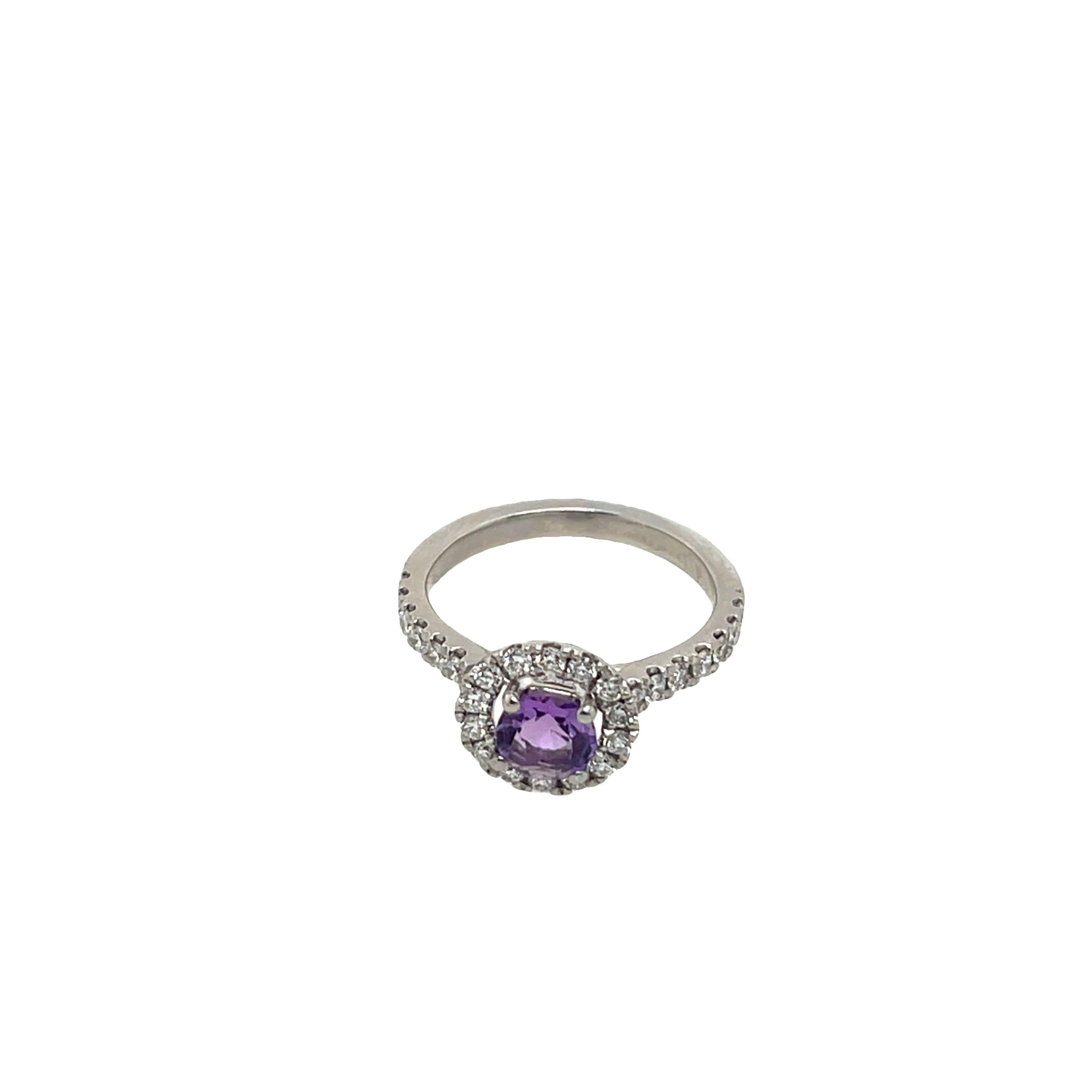 This stunning ring showcases a vibrant amethyst as its centerpiece, surrounded by a sparkling halo of round diamonds. Set in luxurious platinum, the design enhances the brilliance of the diamonds while accentuating the rich purple hue of the