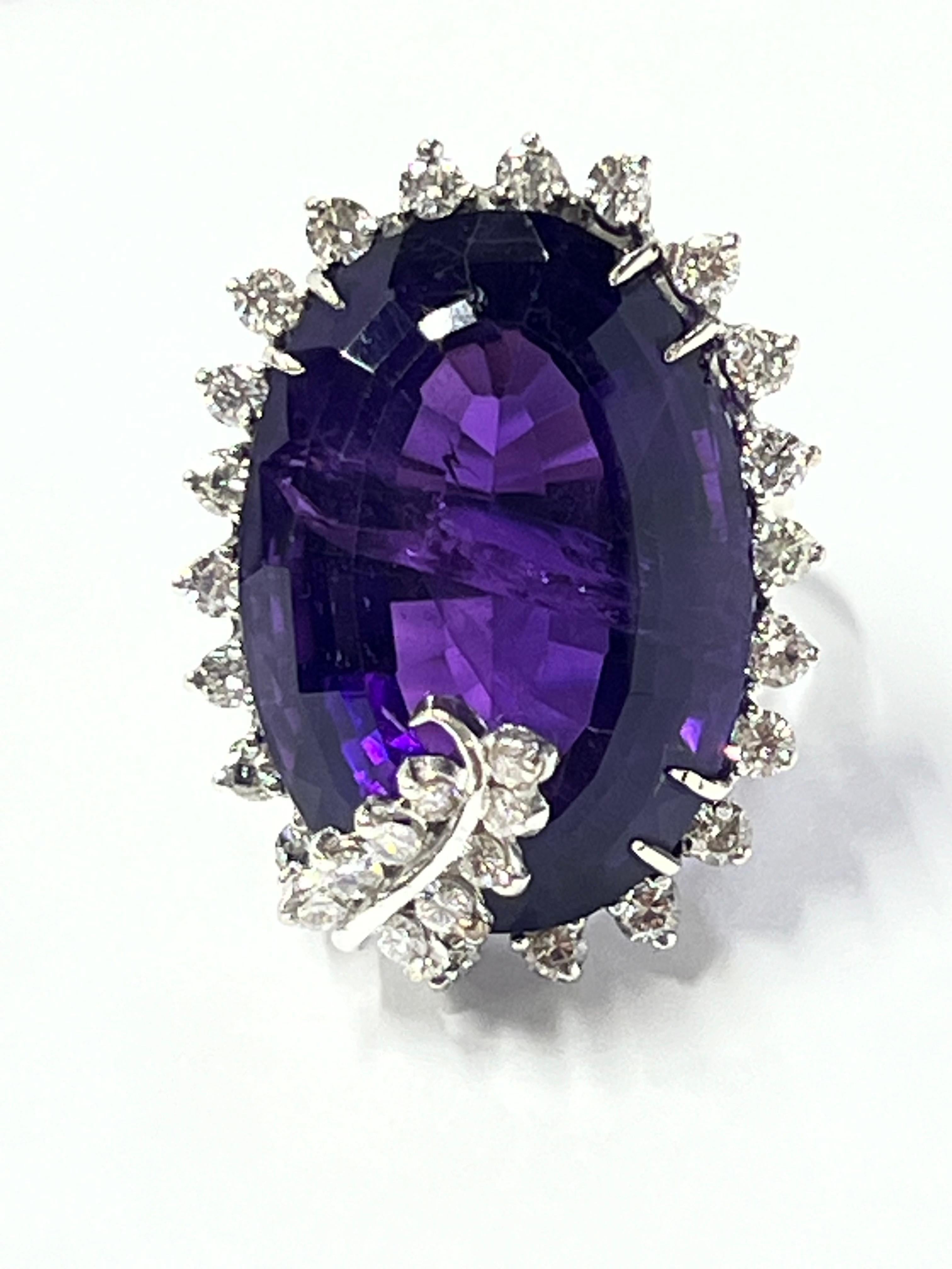 Platinum Amethyst Diamond Cocktail Ring.

Presenting an exquisite platinum and amethyst diamond ring, weighing 18.1 grams, that embodies sophistication and timeless elegance. This stunning piece is accented by a significant natural inclusion, adding