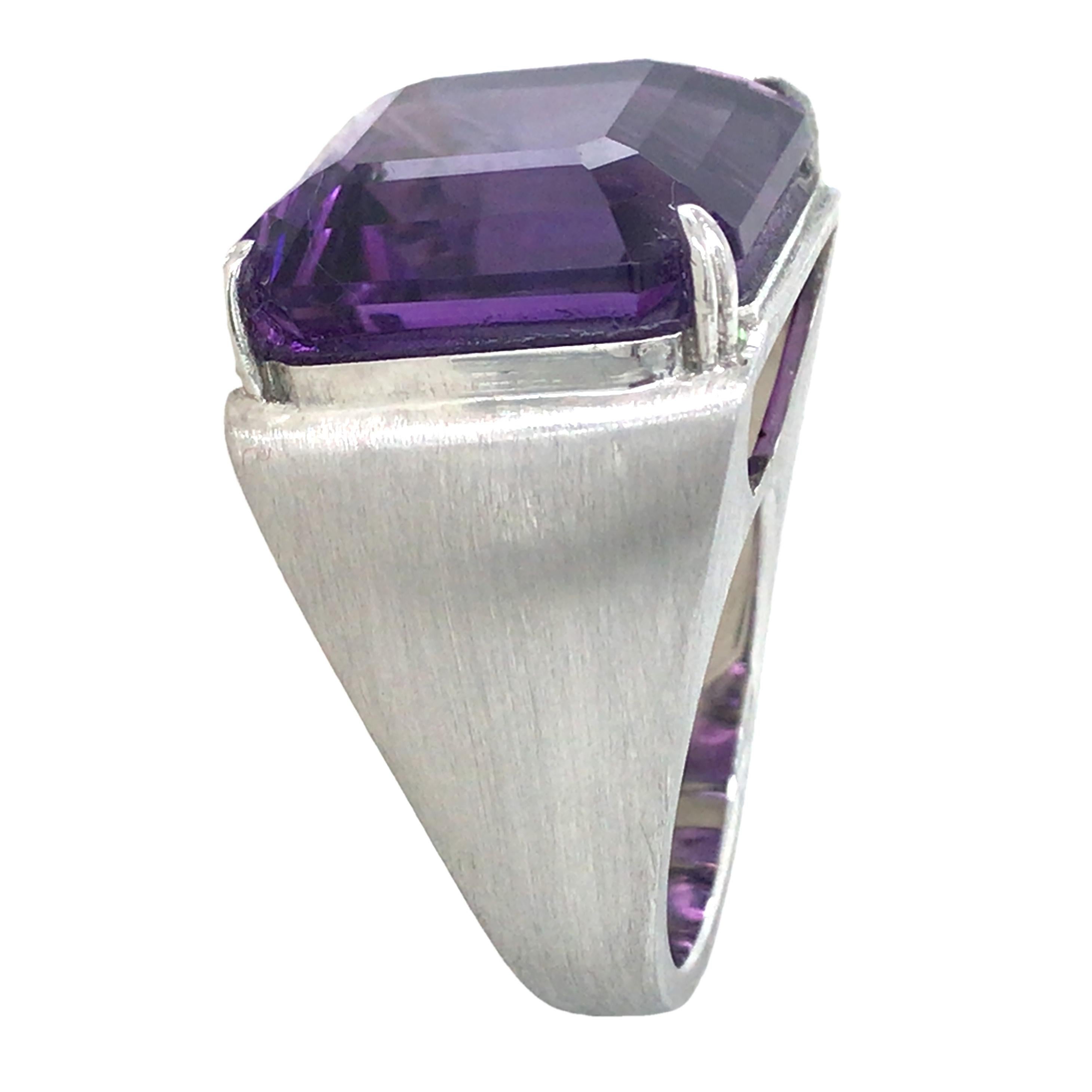 This elegant ring features a richly colored amethyst with a clean, geometric cut that captures and reflects light beautifully. The vibrant purple hue symbolizes nobility and mystery, making it a stunning statement piece. Set in a minimalist design