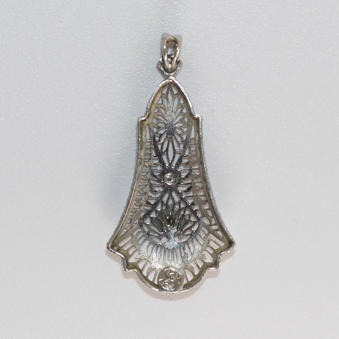 Antique platinum and 14k white diamond pendant.
Stamped 14k & Plat. 
Tests 50% platinum and 30% gold using an XRF metals analyzer.
The pendant weight is 1.7 grams.
The round diamonds are h, i, j color range, Vs clarity, .05 total carats.
Beautiful