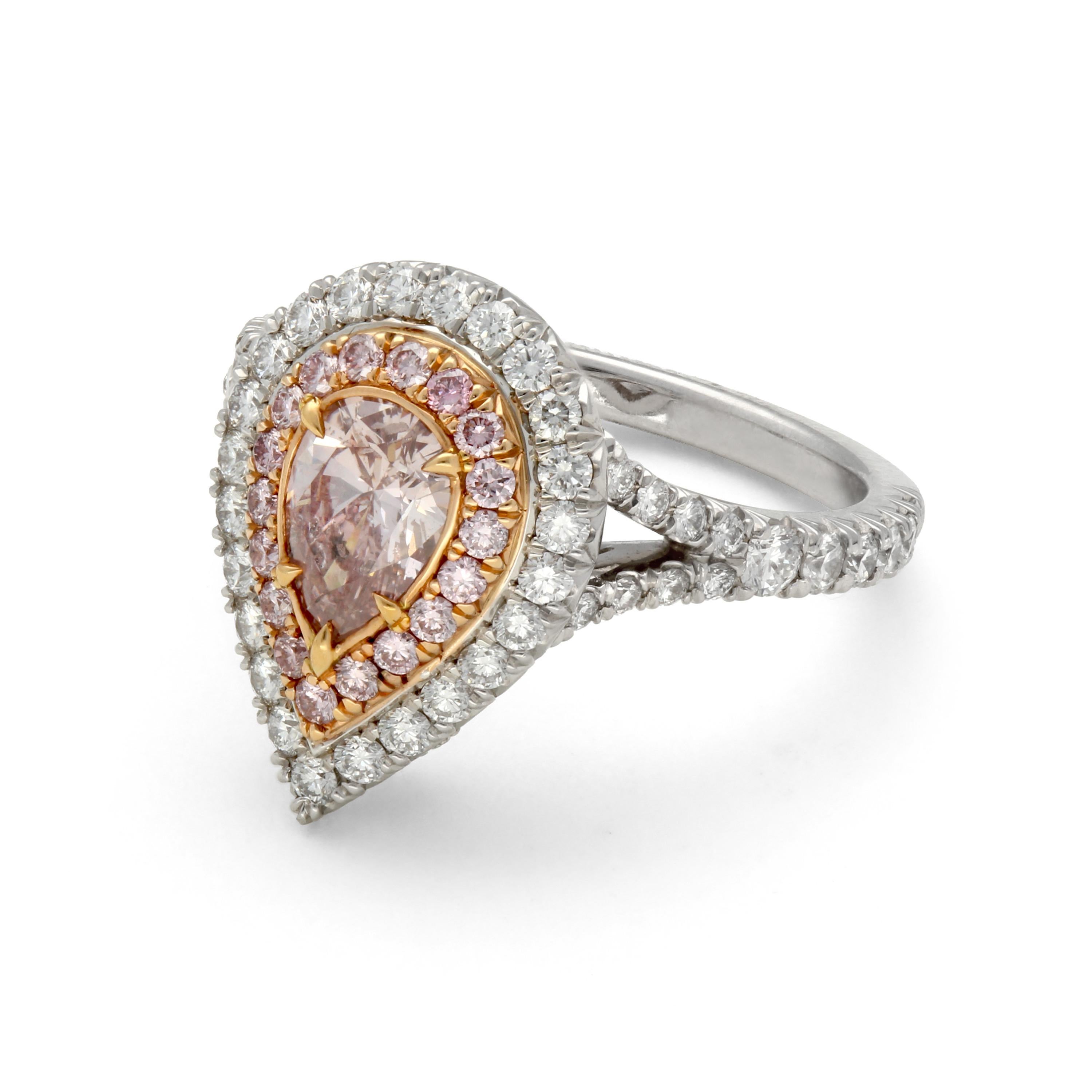 This platinum and 18 karat rose gold engagement ring features a diamond double halo accent and additional diamonds on the trim .  A .69 carat pear shaped fancy pink diamond center is surrounded with .77 total carats of colorless diamonds and .20