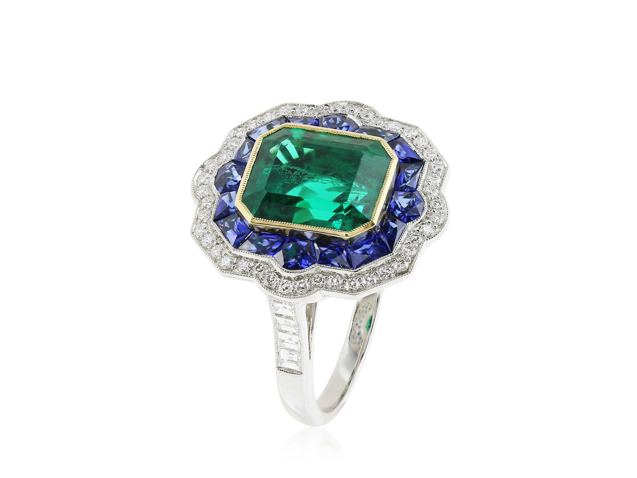 Platinum and 18 karat yellow gold custom ring featuring 1 emerald cut Emerald, weighing approximately 3.68 carats, surrounded by a halo of French cut sapphires with a total weight of approximately 1.05 carats, and accented with full cut diamonds