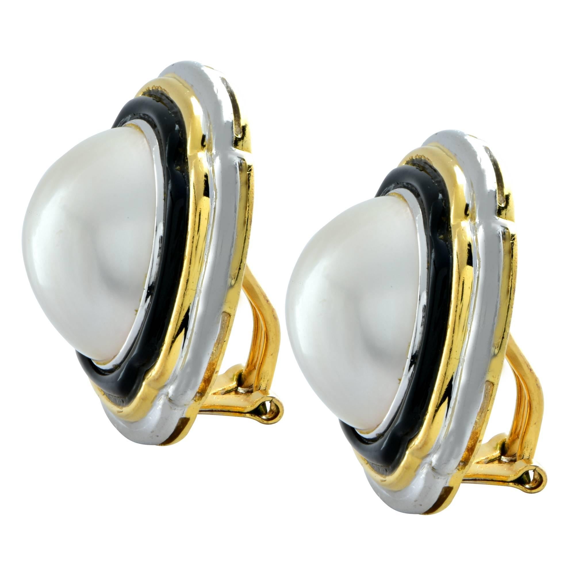 Beautiful platinum and 18K yellow gold earrings featuring Mabe pearls measuring 17mm in diameter. The pearls are framed in enamel, 18K yellow gold and platinum. These attractive earrings measure 1.04 inches by 1.04 inches in diameter. They currently