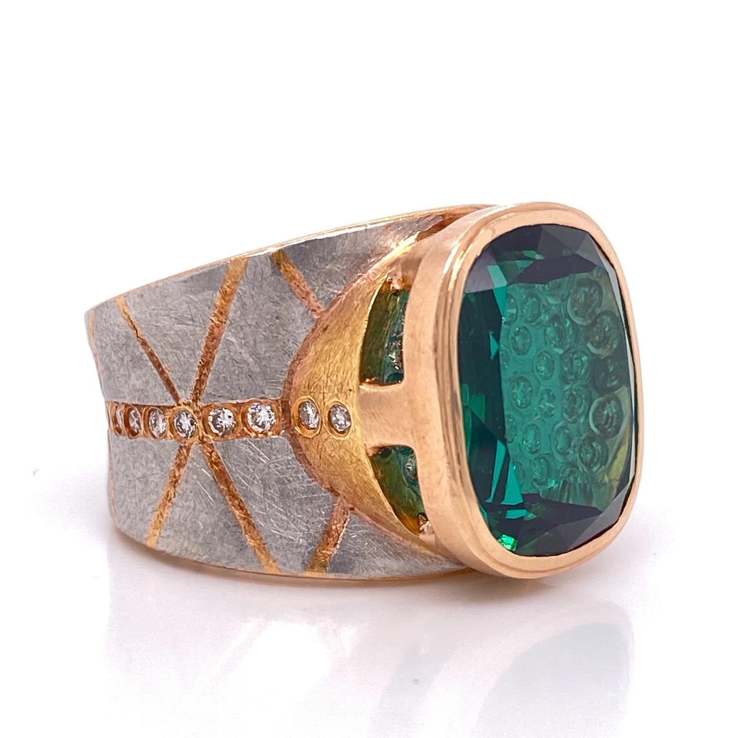 A platinum and 18k rose gold ring set with a 16.12mm x 13.08mm lens cut green tourmaline and 60 round full cut diamonds for a .9 total carat weight.  Designed and made by llyn strong and Michael Zobel as a collaboration.