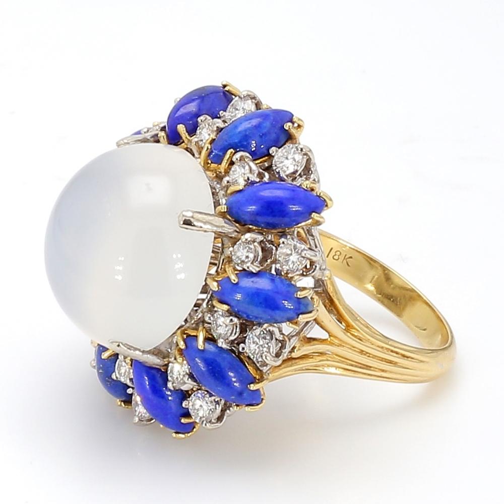 Platinum and 18K yellow gold, cocktail ring. Center stone is one (1) round, cabochon cut moonstone weighing 15.60ct. Moonstone measures approximately 16.4mm. Moonstone is surrounded by 20m (twenty) round brilliant cut diamonds weighing approximately