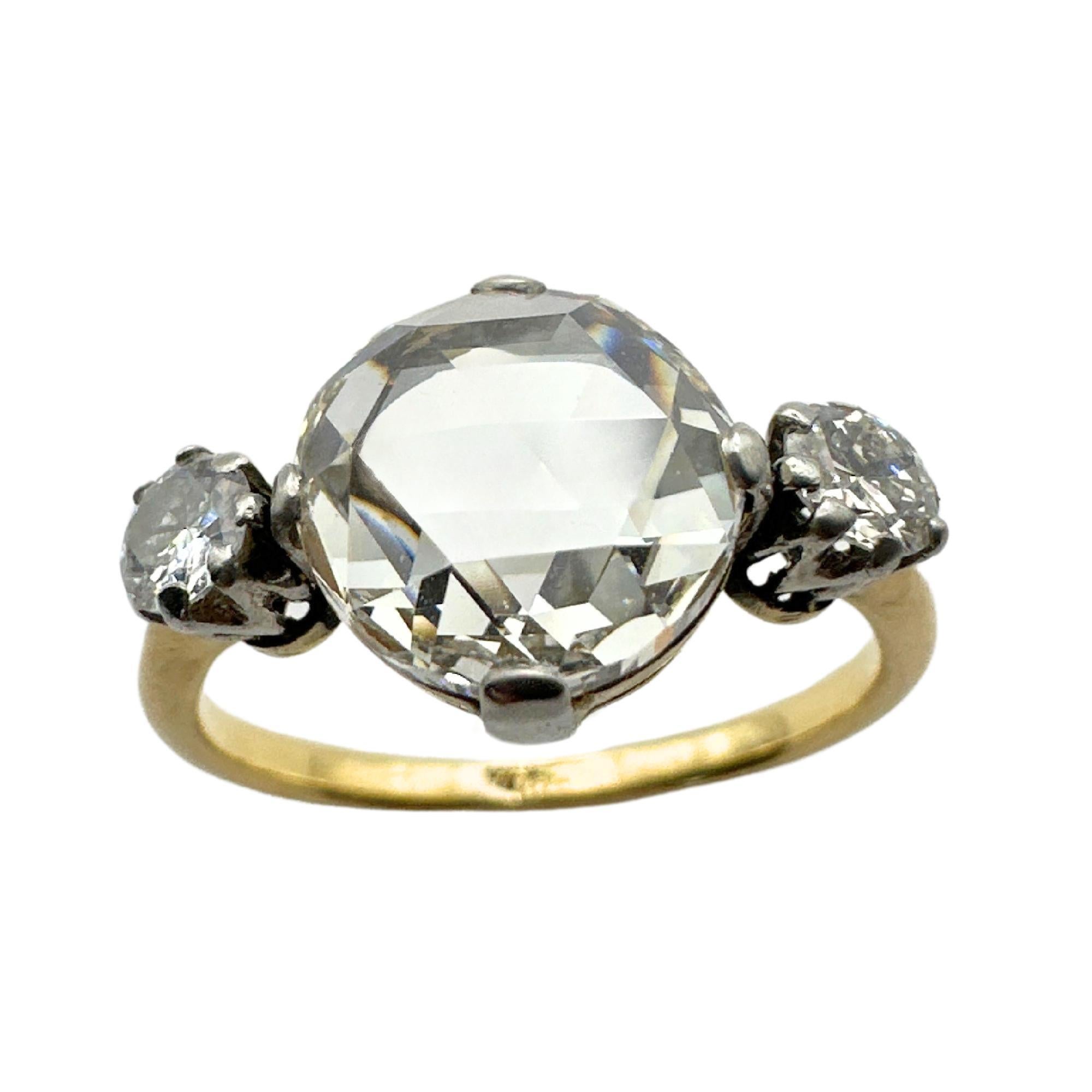Erhöhen Sie Ihre Liebe mit unserem exquisiten viktorianischen 18k-Drei-Stein-Diamant-Verlobungsring. Dieses frühviktorianische Schmuckstück ist mit einem atemberaubenden runden, modifizierten Brillanten von 2,15 Karat besetzt, der in einer
