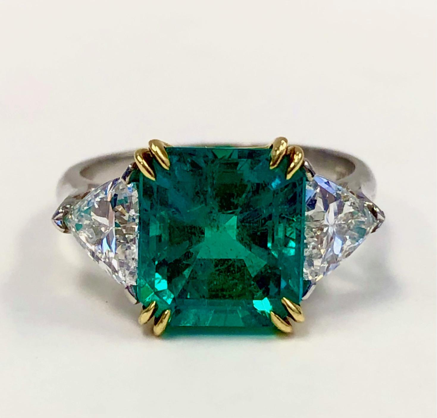 Classic and elegant three stone ring, handmade in Platinum and 18K Yellow Gold, set with a fine Colombian Emerald 3.47 carats and a matching pair of high quality Trillion Diamonds 1.26 carats.

We design and manufacture our jewelry in our workshop,