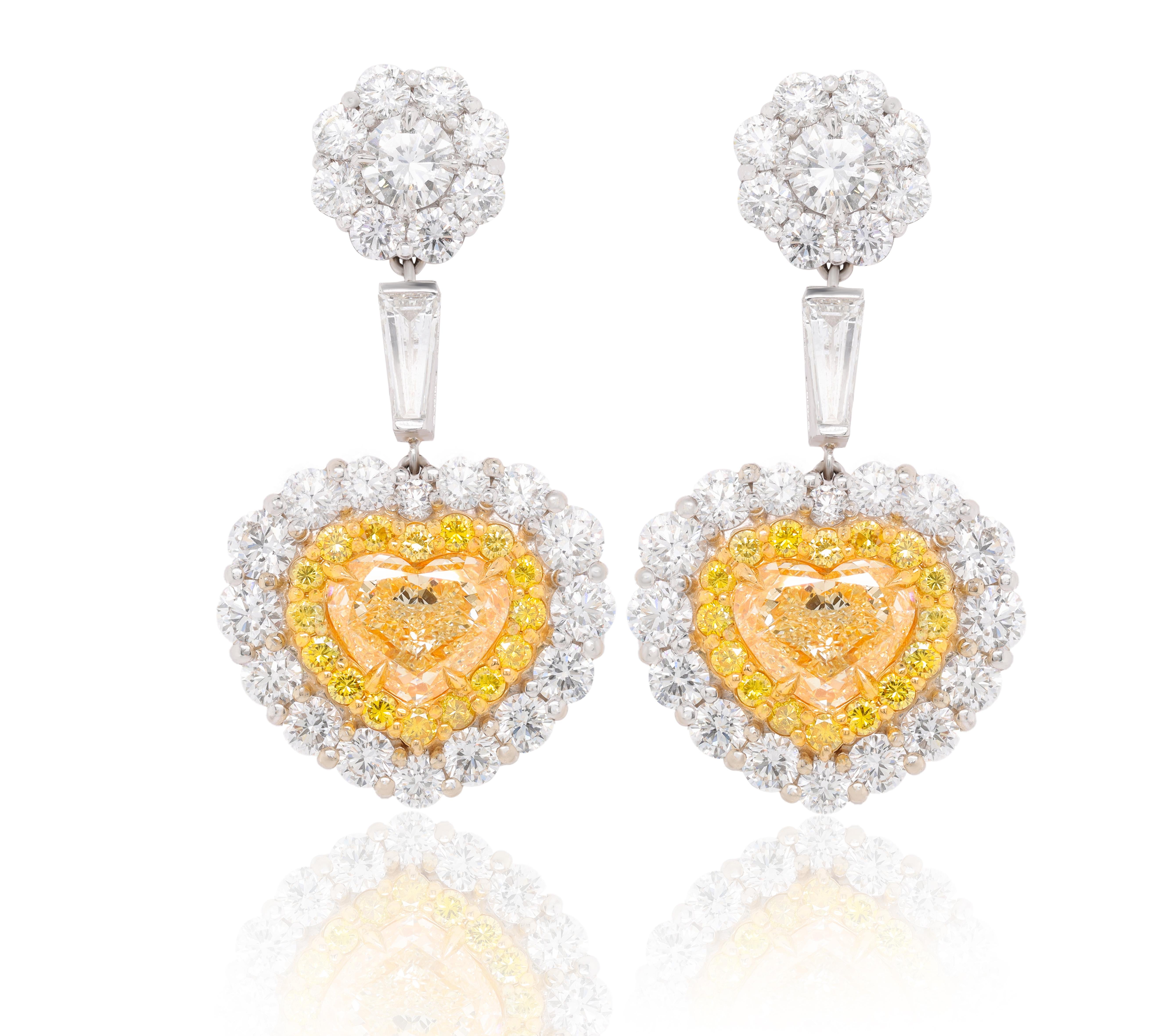 Platinum and 18kt magnificent diamond earrings. These earrings contain 6.85ct of fancy yellow diamonds vvs-vs clarity (htc-69)(htc-68) heart shapes and 11.50ct of round  diamond halo with a large halo top on a suspended baguette  all handmade 
