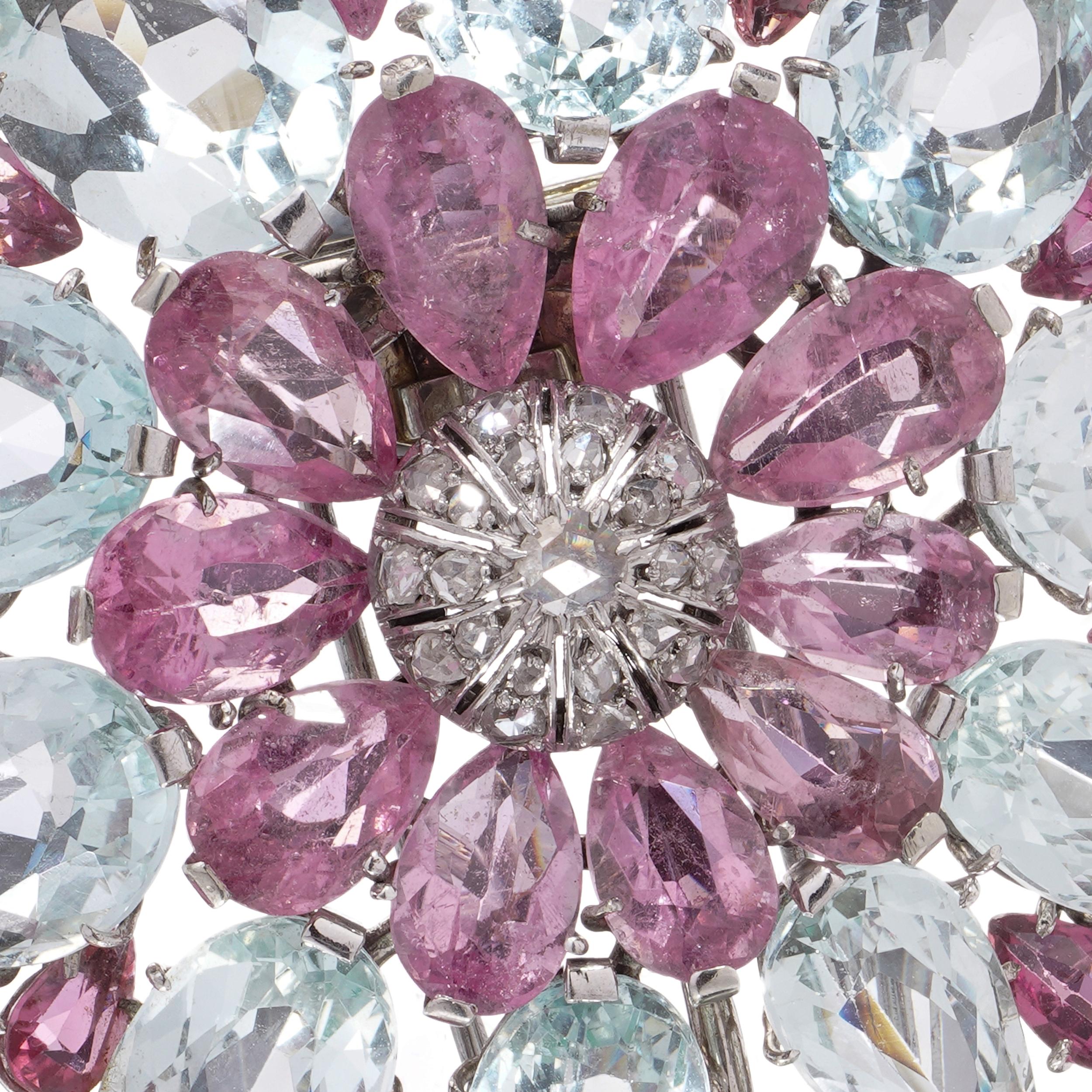 Un'impressionante spilla vintage a spruzzo floreale, magistralmente realizzata in platino e oro bianco 9kt. Il design presenta petali alternati di grandi acquamarine a taglio misto e kunziti rosa, con accenti di kunziti rotonde e a forma di pera