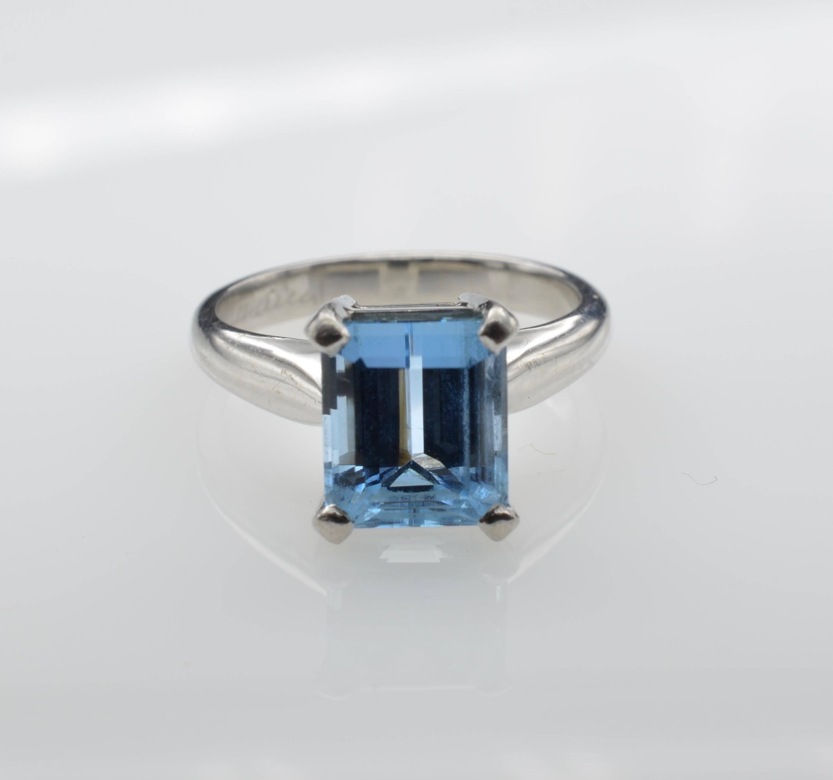 This stunning emerald cut aquamarine is 2.82 carats VVS clarity. The size of the stone measures 8.5 x 7.35 x 5.7mm. The platinum mounting beautifully accents the deep blue color of the aquamarine. It is simply elegant and timeless. The ring is a