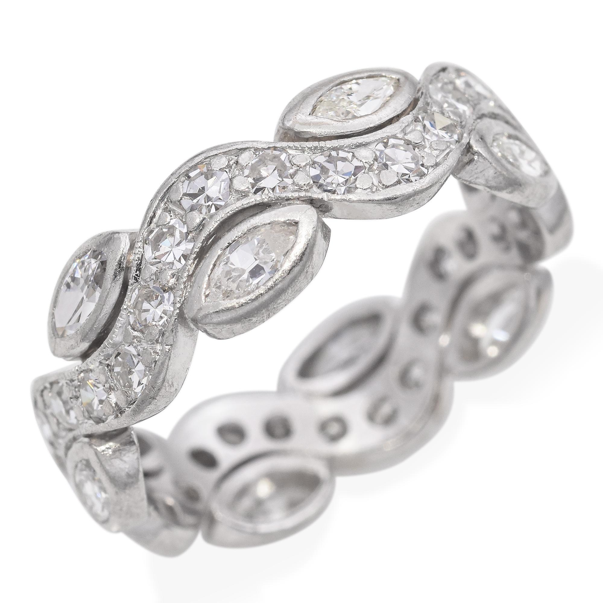 Cette élégante bague est réalisée en platine et présente un anneau fluide et ondulé avec des diamants taille marquise alternés. La bande combine des détails de perles et de taille brillante, ajoutant de la texture et de l'éclat tout au long de la