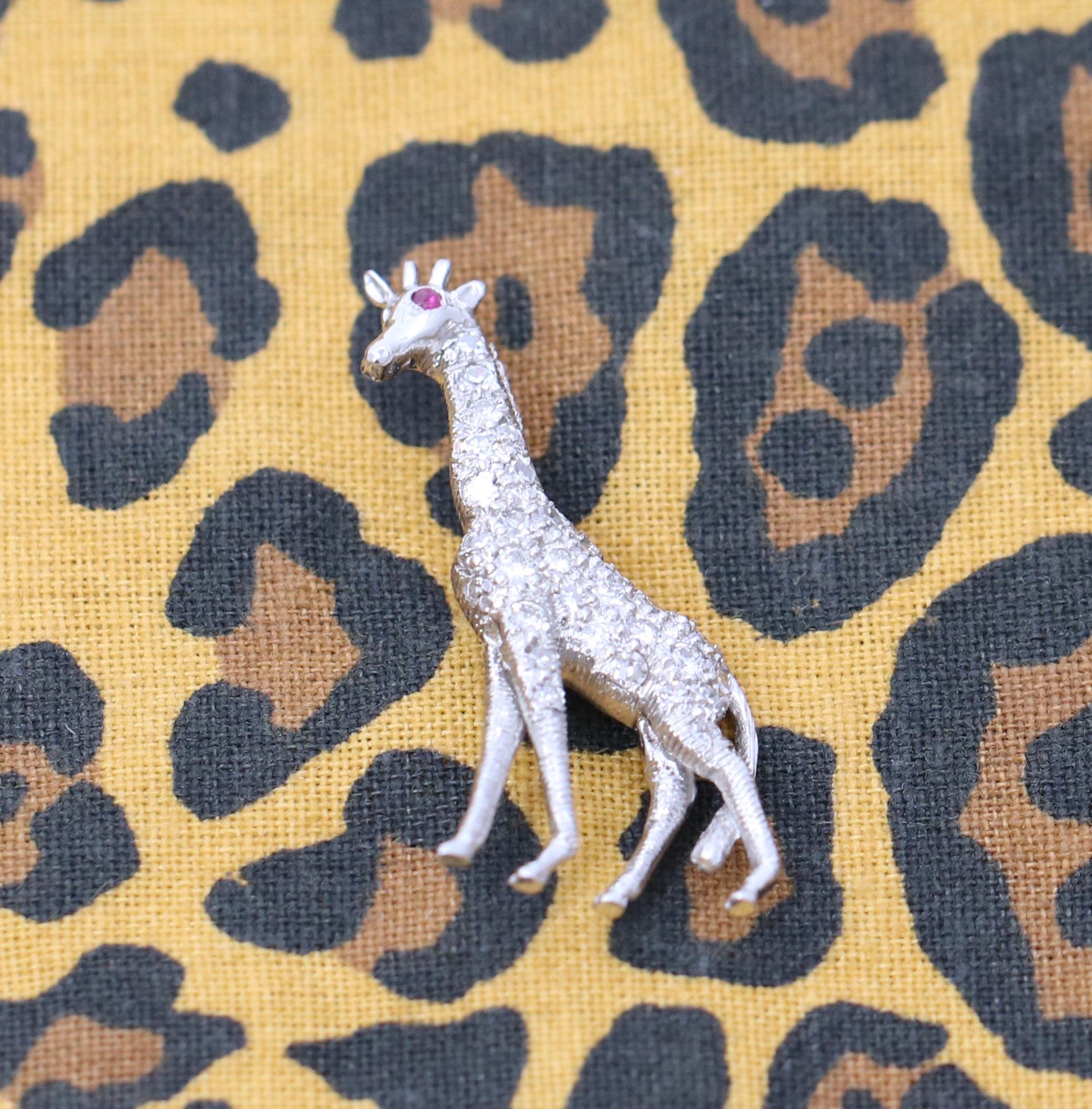 An Art Deco, platinum stickpin, of a tall giraffe, beautifully pave' set with assorted round brilliant, and single cut diamonds. Featuring a ruby eye, this giraffe measures 1 1/8 inches long, and 9/16 of an inch wide. Measuring 2 1/8 inches long
