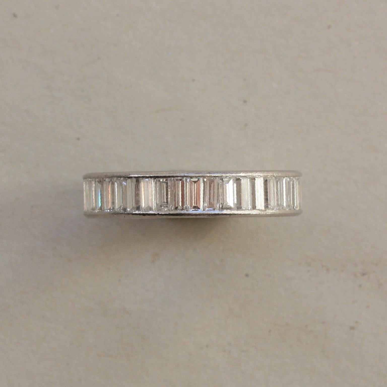 A platinum band ring set with baguette cut diamonds, (each circa 0.07 carat, app. 3.08 carat in total), vertically set, American, circa 1950 and numbered: CJ 551.

ring size: 17 mm. 6.5 US
weight: 4.58 grams
width: 4 mm
