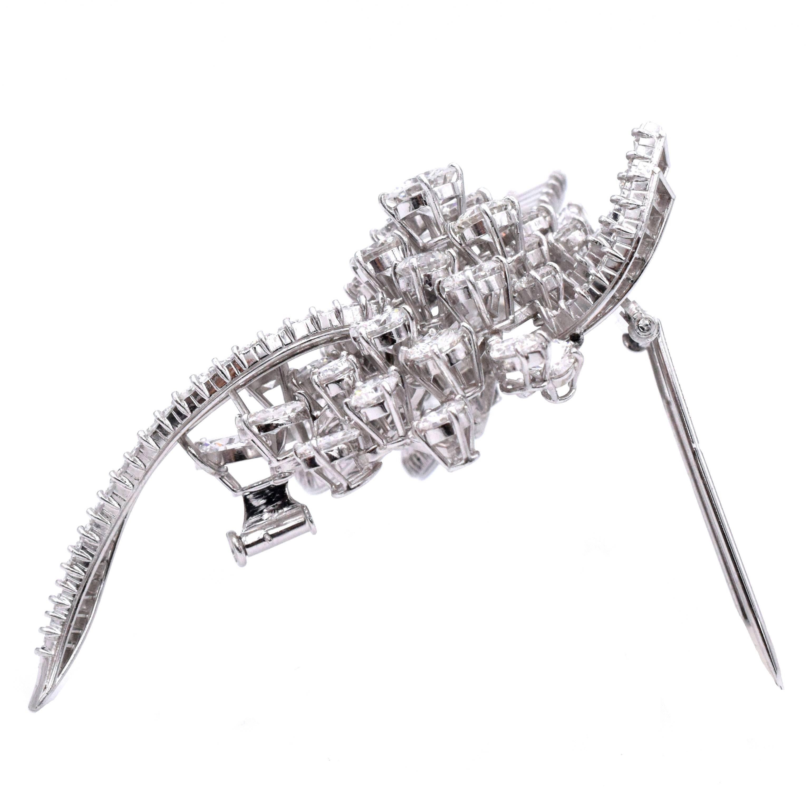 Timeless & Elegant Brooch.  French
The stylized bow centering one round diamond approximately .90 ct., within a cluster of 28 round diamonds approximately 10.00 cts., tipped by 7 marquise-shaped diamonds approximately 2.00 cts., within ribbons of 90