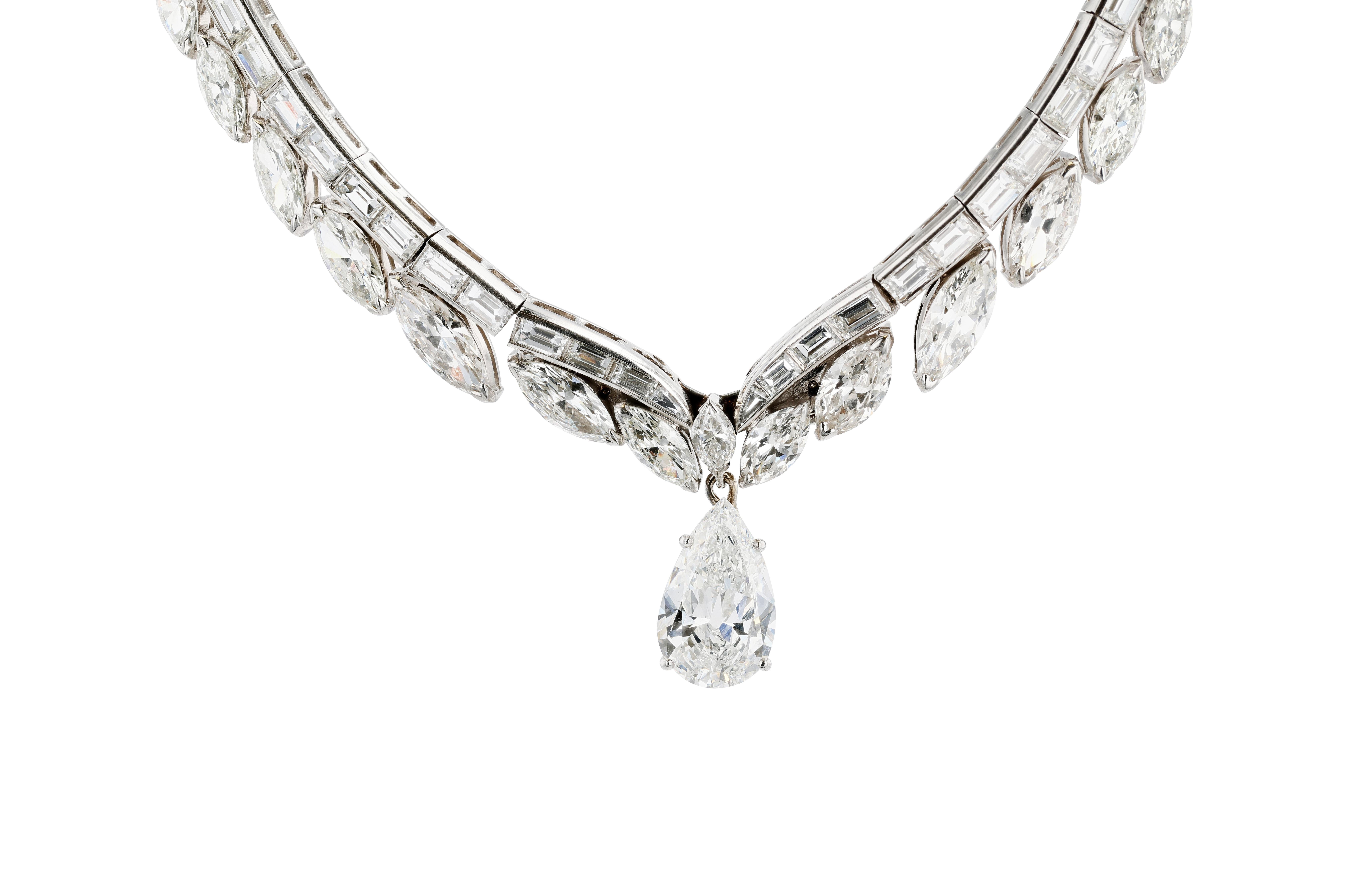 An important platinum (PT950) and natural diamond drop necklace featuring approximately 30 carats of baguette and marquise shaped diamonds and a center stone of pear shape weighing an additional 3.56 carats.

The main body of the necklace is