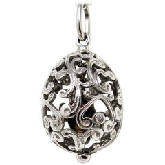 Pendentif œuf Fabergé en platine et diamant:: avec détails en volutes ouvertes:: breloque cœur à l'intérieur