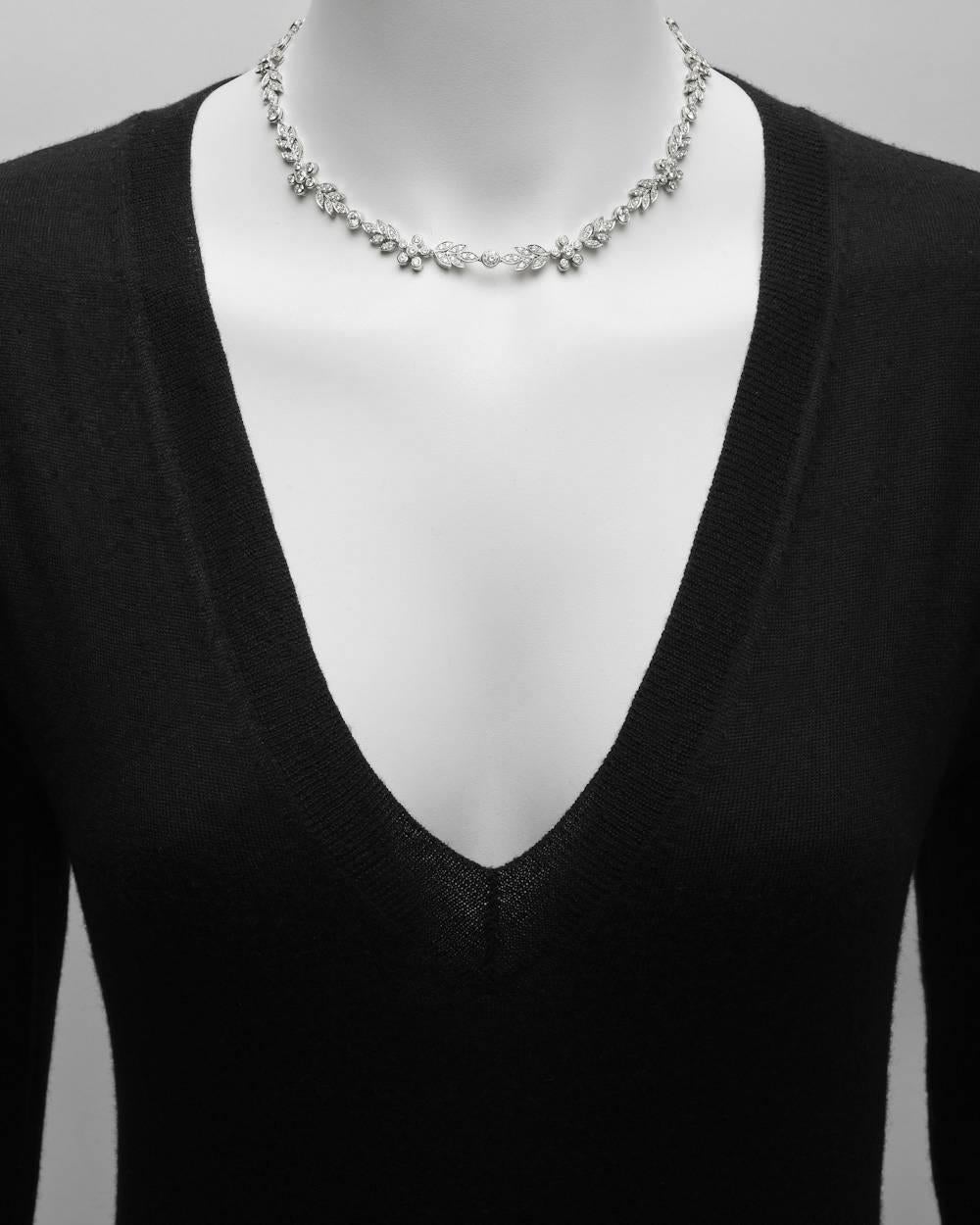 Diamond collar necklace, showcasing a variety of diamond-set floral motifs, in platinum. Near-colorless round brilliant-cut diamonds weighing approximately 8.35 total carats (H-color, SI-clarity, or better). 16