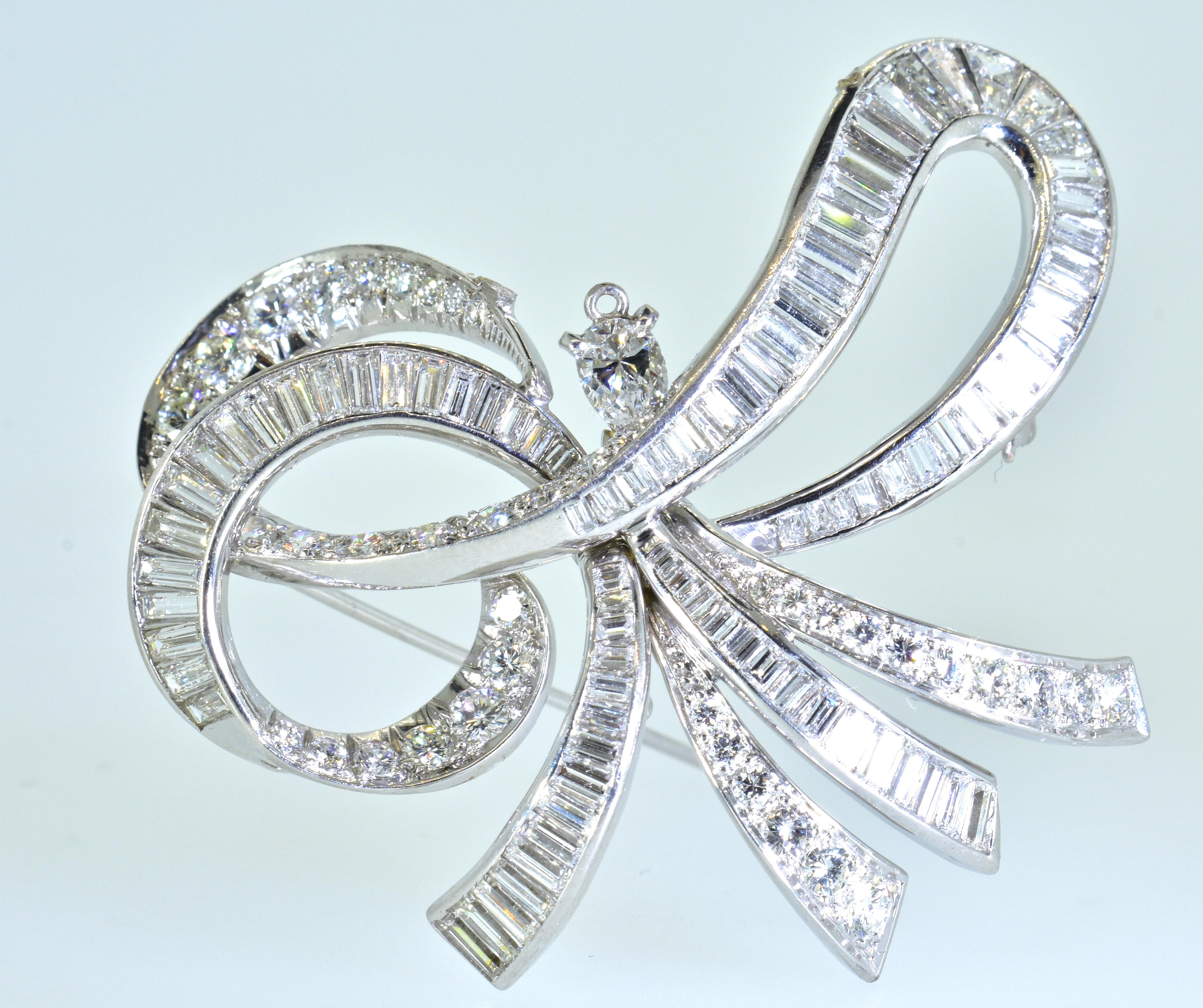 Diamond and platinum brooch (or pendant) in a stylized bow motif.  Composed of 4 different cuts of fine white diamonds - round brilliant cuts, a pear cut, baguette cuts, and tapered baguette cuts.  These diamonds are all of the same fine quality -
