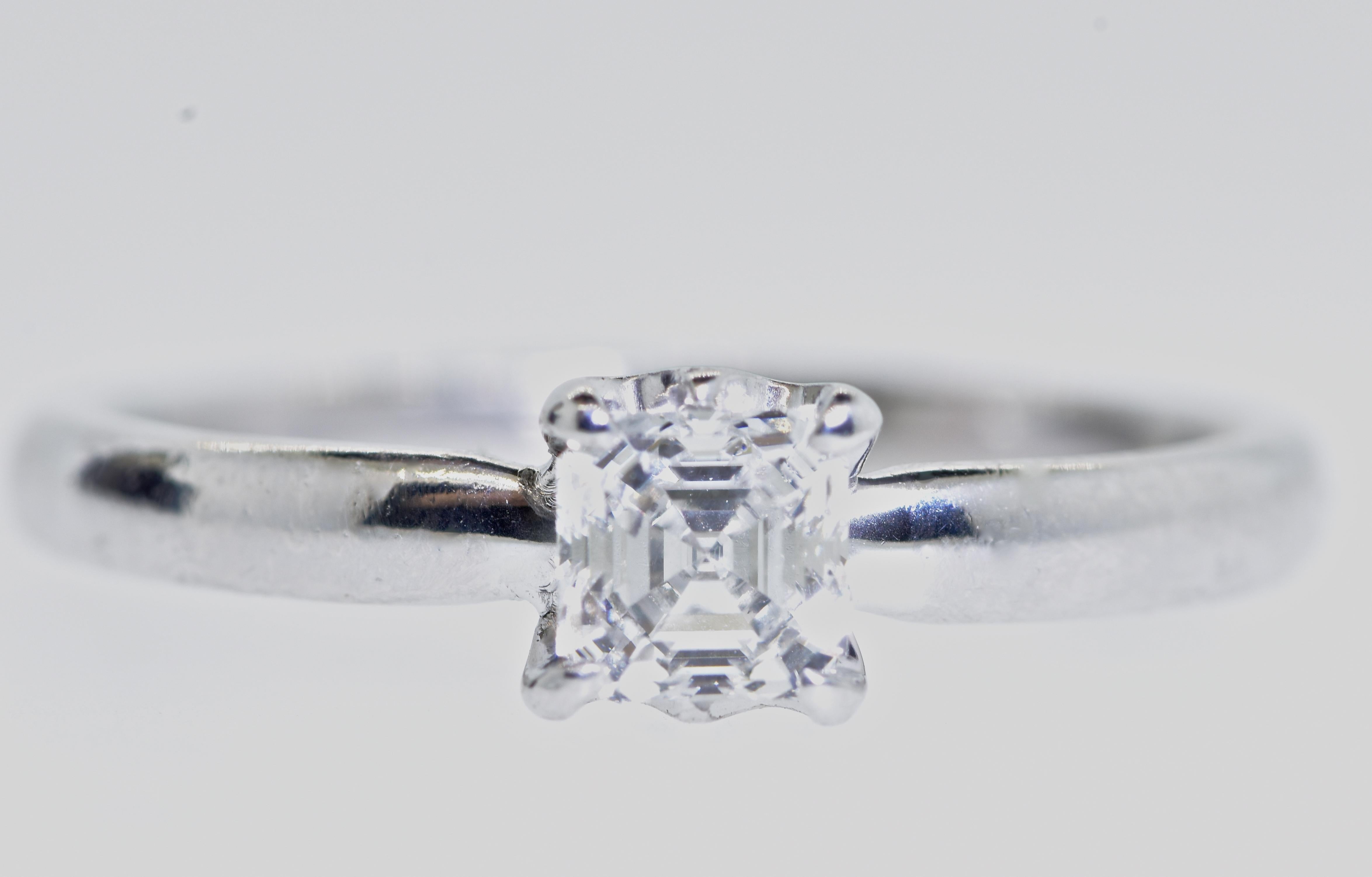 De Beers diamond solitaire platinum ring.  The center prong set square cut diamond is very white - F/G (colorless to beer colorless), and very very slightly included.  This very fine diamond is estimated to weigh .40 cts., is well cut with fine