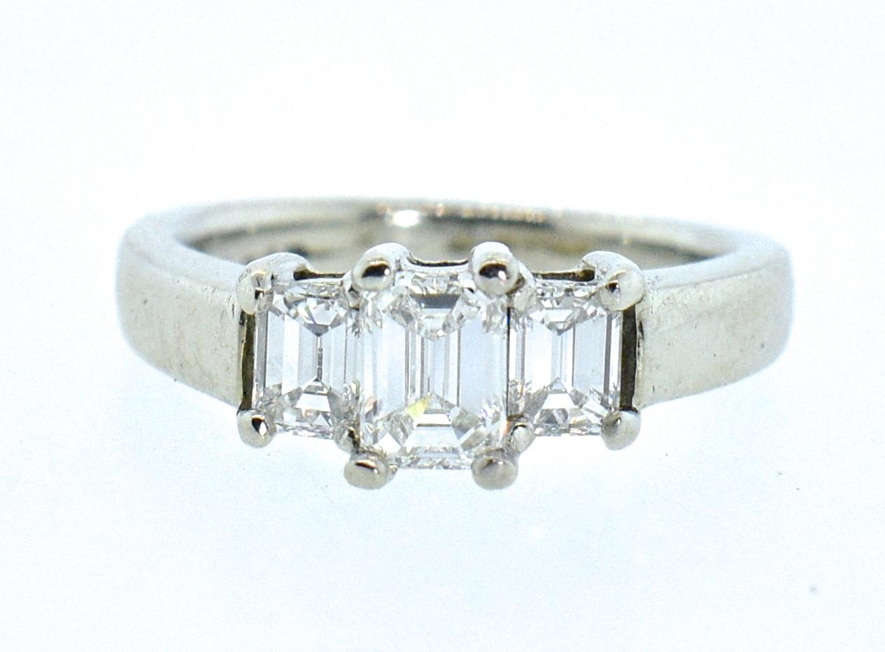 Diamond and platinum ring possessing 3 fine white emerald-cut diamonds.  All well cut and well matched, all approximately H in color (near colorless), and very slightly included (VS).  The center diamond weighs approximately .57 cts., ad the side