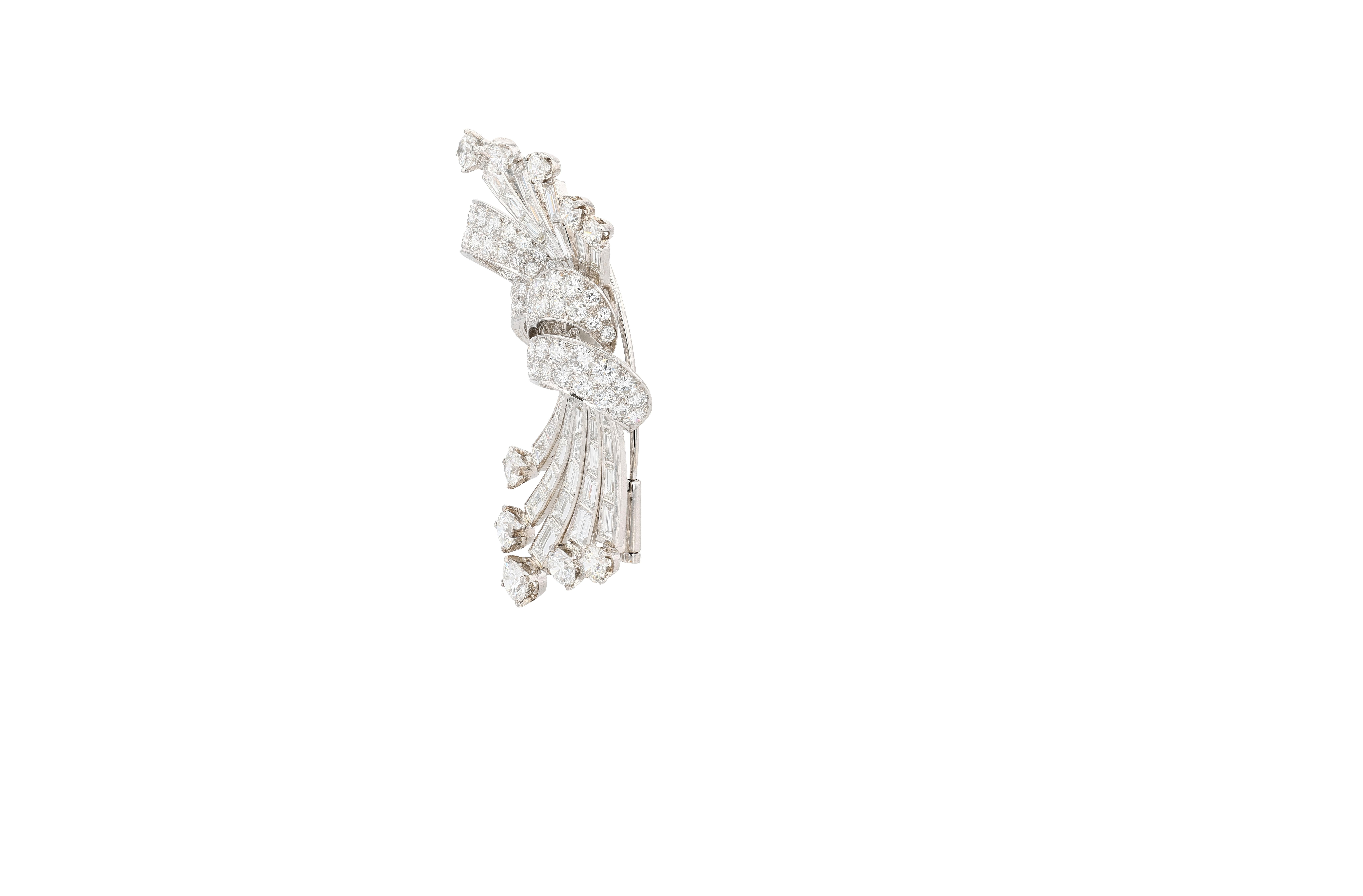 Broche en platine (PT950) et diamants multi-taillés, très représentative de l'époque, à motif de spray. La broche représente un ruban serti de diamants ronds et brillants pave, serrant des tiges de diamants baguettes et ronds et brillants qui
