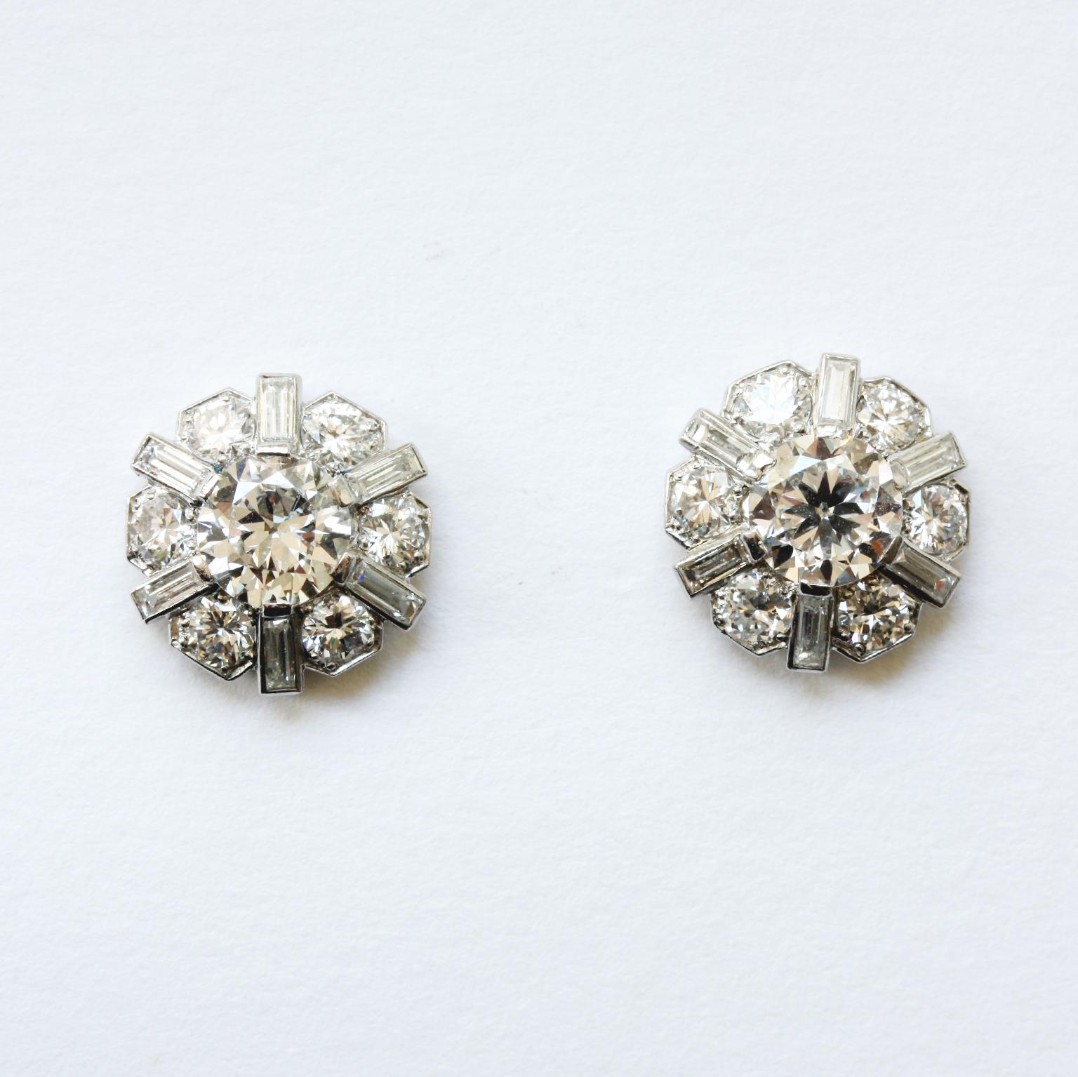 A beautiful pair of platinum stud earrings set with an old-cut diamond (centre stones app 0.95 and 0.98 carat) around which are 6 smaller old-cut diamonds and 6 baguette-cut diamonds (app. 4.3 carats in total, colour I-J, VS1). Circa 1950.

Weight: