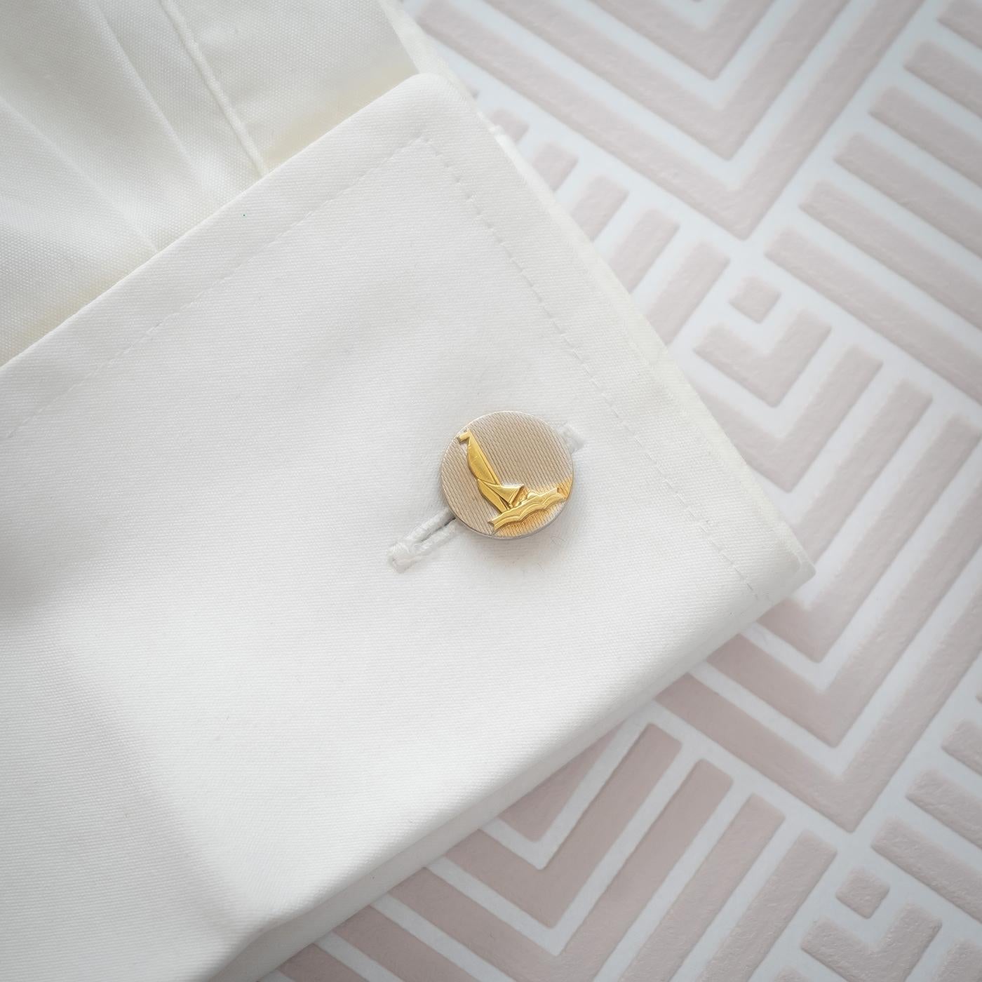 A pair of platinum cufflinks, comprising of a circular engine-turned platinum disc, with a gold plated sailing boat on each, with chain link fittings, circa 1950.