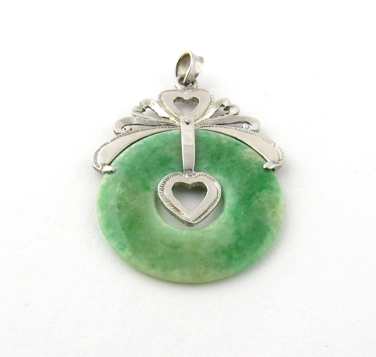 Vintage Sterling, Palladium and Jade Heart Circular Pendant

Hangs 42 mm in length 28 mm wide

2mm thick

3.15 dwt /4.9 g

The metal was X-rayed and determined to be 72% silver and 10% palladium.

Does not come with chain - chain available upon