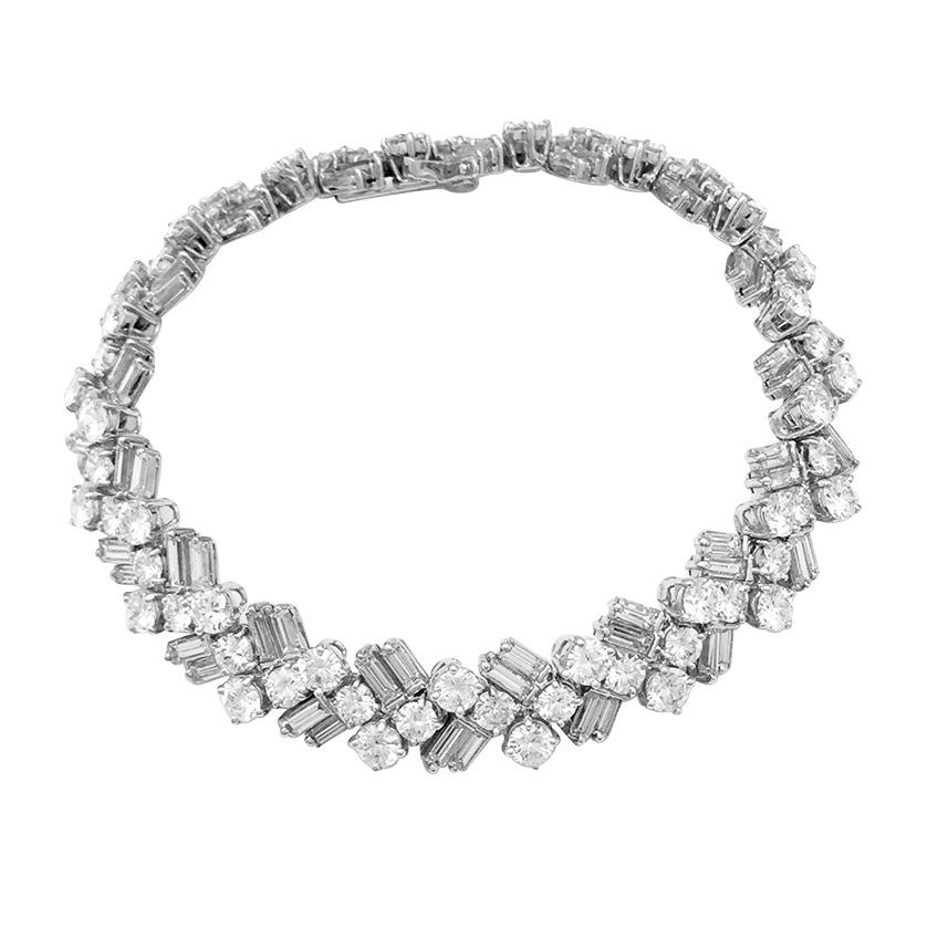 A 950/000 platinum and 750/000 white gold diamonds bracelet made with seventeen links, each is set with four brilliant cut diamonds and four baguette cut diamonds. 
Width : 9 mm
Length : 170 mm
Total weight of diamonds : about 12 carats
Diamond