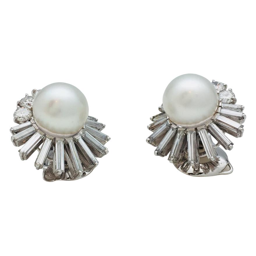 A 950/000 platinum and 750/000 white gold pair of earrings signed by M. Gérard, each is centered with a round white South Sea pearl, surrounded with baguette and brilliant cut diamonds.    Clip system. 
Pearl diameter : 11 mm
Length : 22 mm   Width