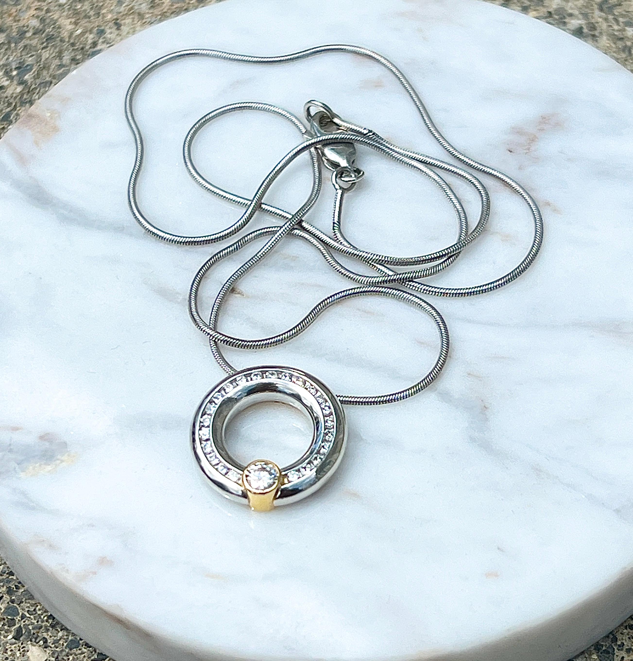 One platinum and 18 karat yellow gold pendant set with twenty-three round brilliant diamonds approximately 0.35 total carat weight with matching J color and VS2 clarity and one round brilliant diamond approximately 0.17 carat with I color and SI1