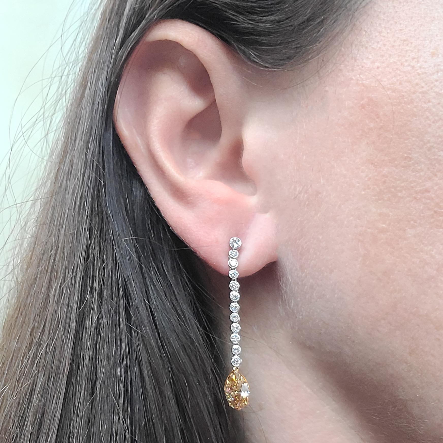 Platinum & 18 Karat Yellow Gold Drop Earrings Featuring 2 Prong-set Marquise Cut Diamonds Of Fancy Brownish Orange Color & VS/SI Clarity Totaling 1.97 Carats. 24 Additional Bezel-Set Round Brilliant Cut Diamonds Of VS Clarity & G Color Total 0.86