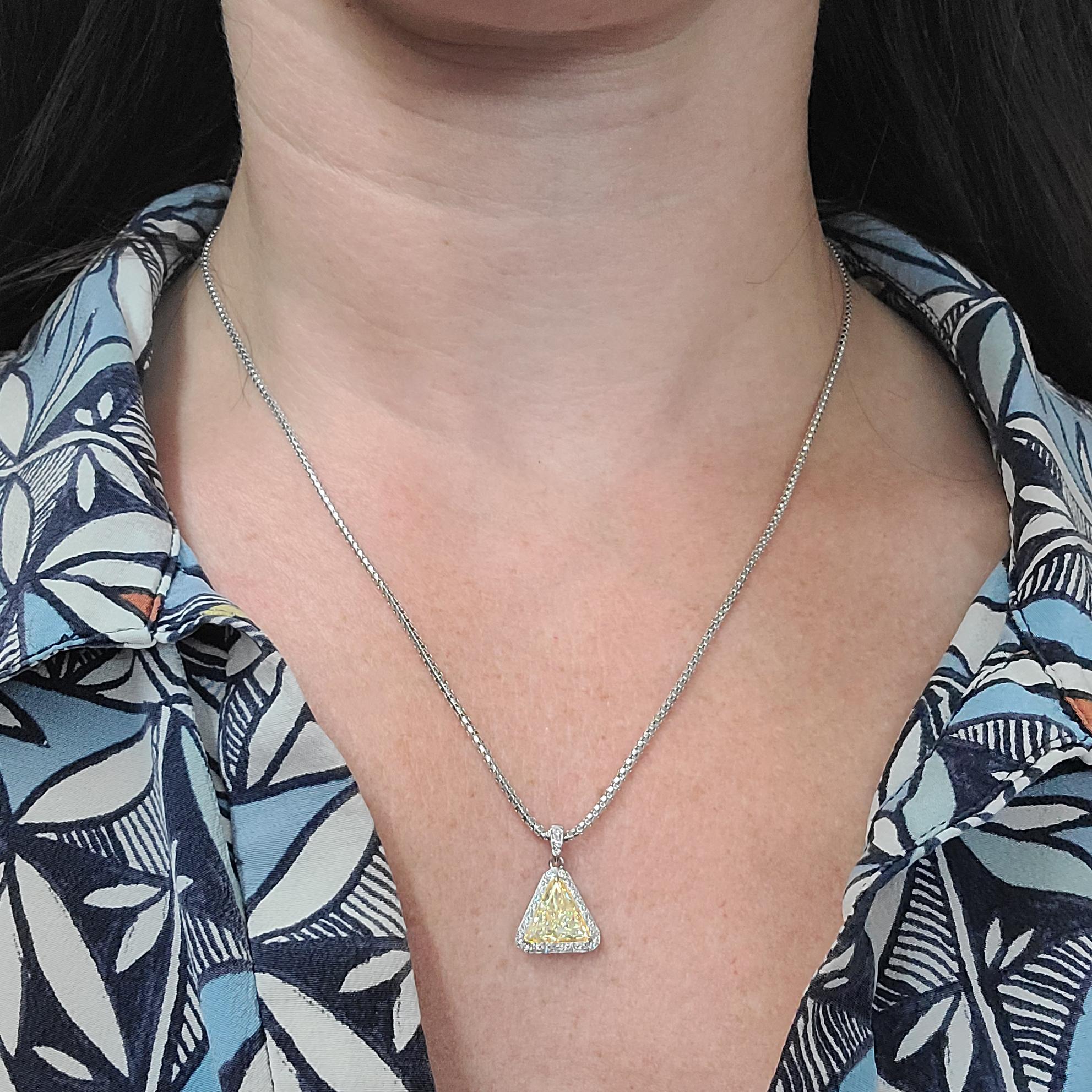 Platinum & 18 Karat Yellow Gold Pendant Necklace Featuring A Triangular 1.23 Carat Natural Yellow Diamond Of VS Clarity Surrounded By 28 Round Brilliant Cut Diamonds Of VS Clarity & G Color Totaling 0.20 Carats. 1.5mm Wide Platinum Chain Is 18