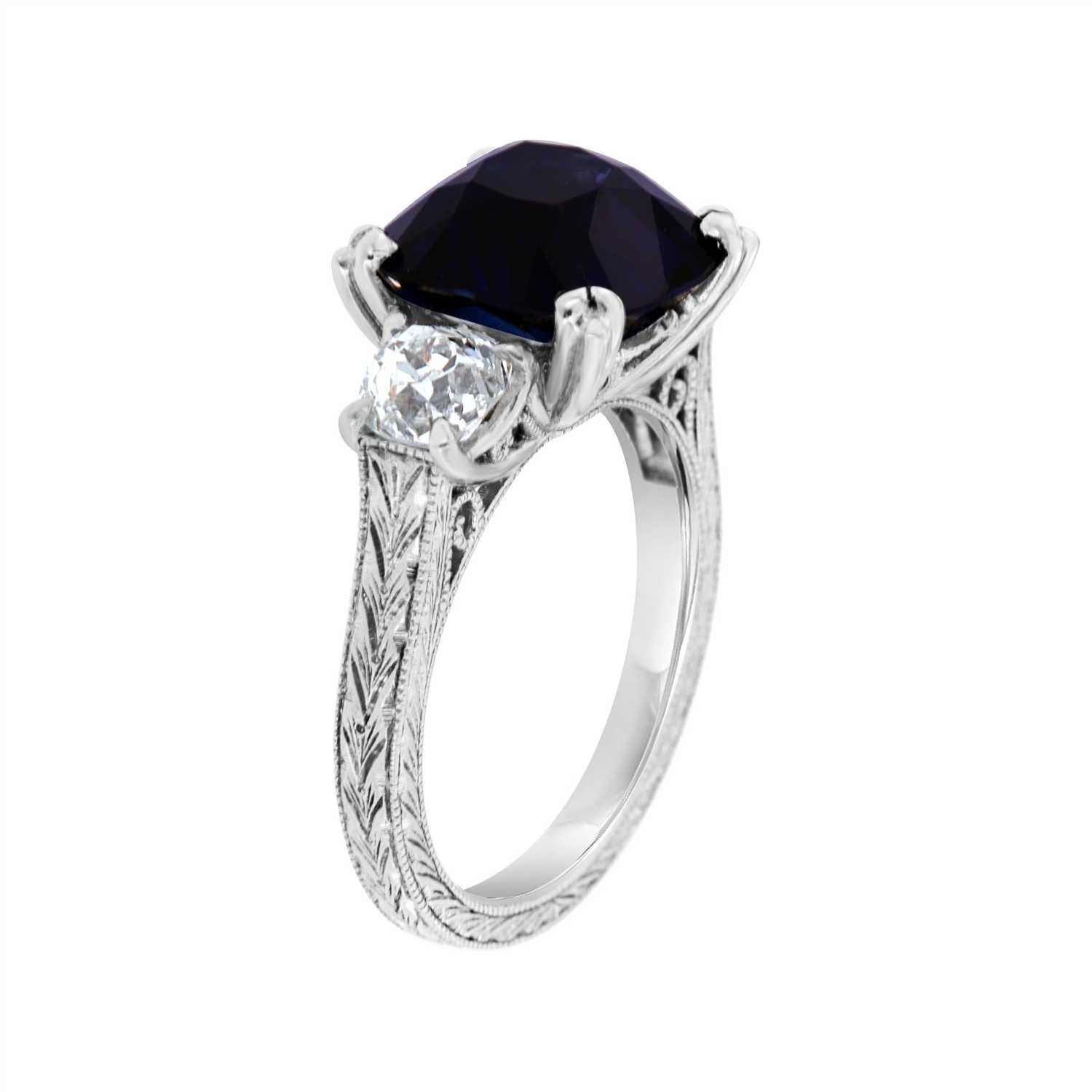 This Platinum Art Deco Estate ring features a 5.66 Carat Royal Blue Natural Antique Cushion shape Sapphire  GIA Certificate 5201103617. Flanked by two old-mine cut diamonds weighing 1.16 Carat GIA certificates 5191781639 and 5191590933. The sapphire