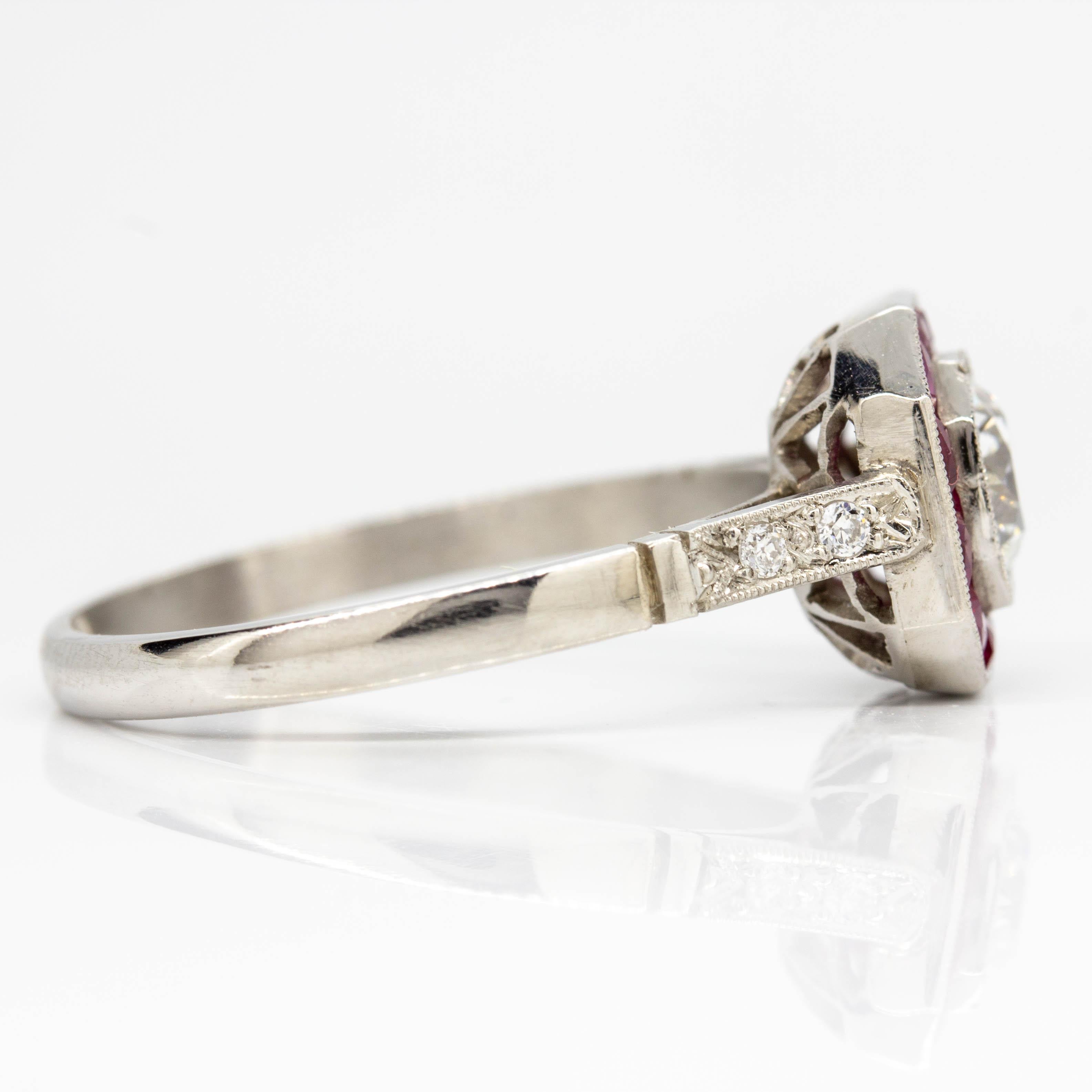 Composition: Platinum
•	1 old mine cut diamond I-VS1 0.60ctw.
•	12 natural calibrated cut rubies 1.20ctw.
•	4 old mine cut diamonds H-VS2 0.06ctw.
Ring size: 7 ¼ 
Ring face measure: 11mm by 12mm
Rise above finger: 6mm
Total weight:  3.8 grams –