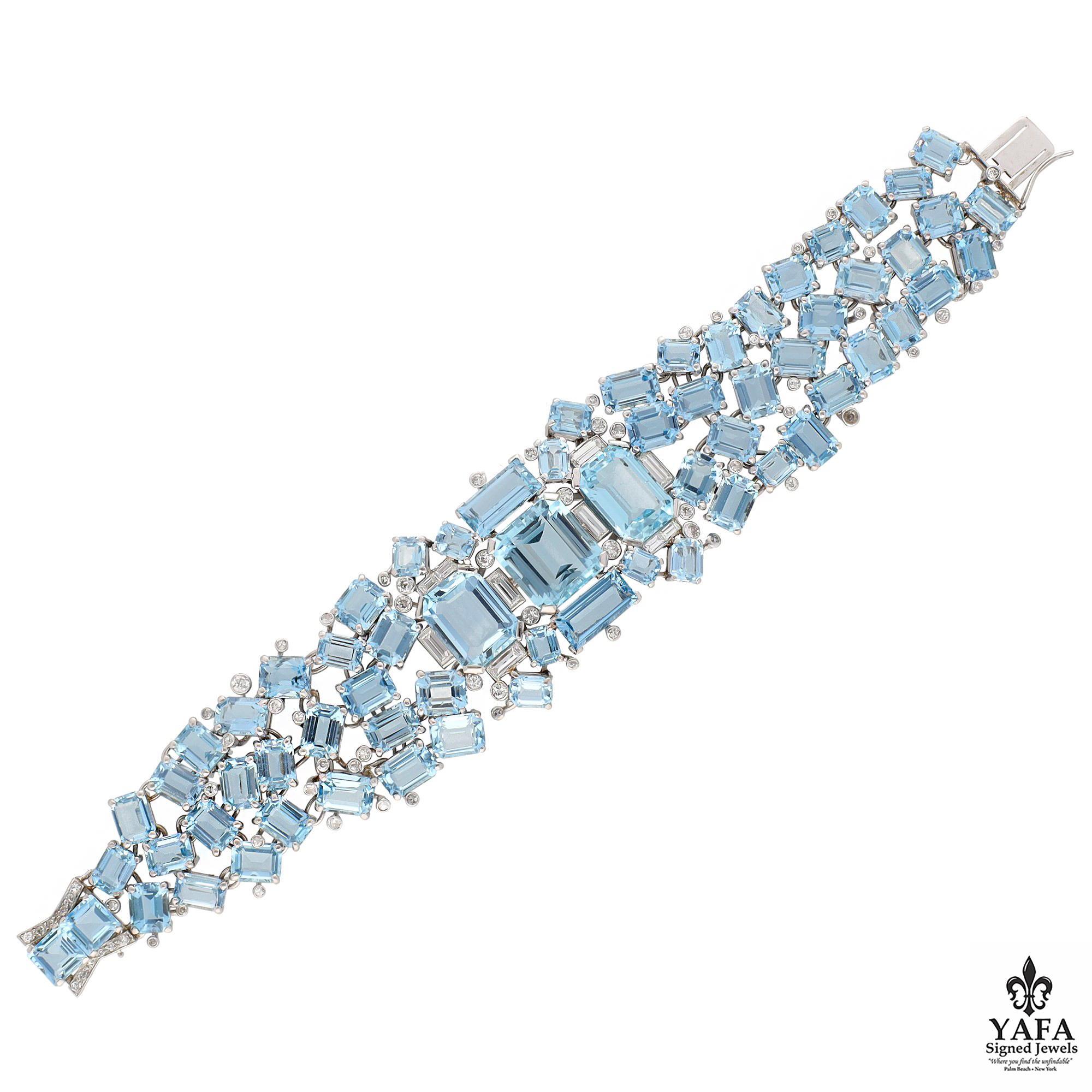 62 Vibrantly Electric Emerald Cut Aquamarines, Creatively Scattered Yet Highly Intricately Placed are Joined in the Center by 3 Additional Emerald Cut and 2 Baguette Cut Aquamarines. Further, Round and Baguette Diamonds are Interspersed Completing