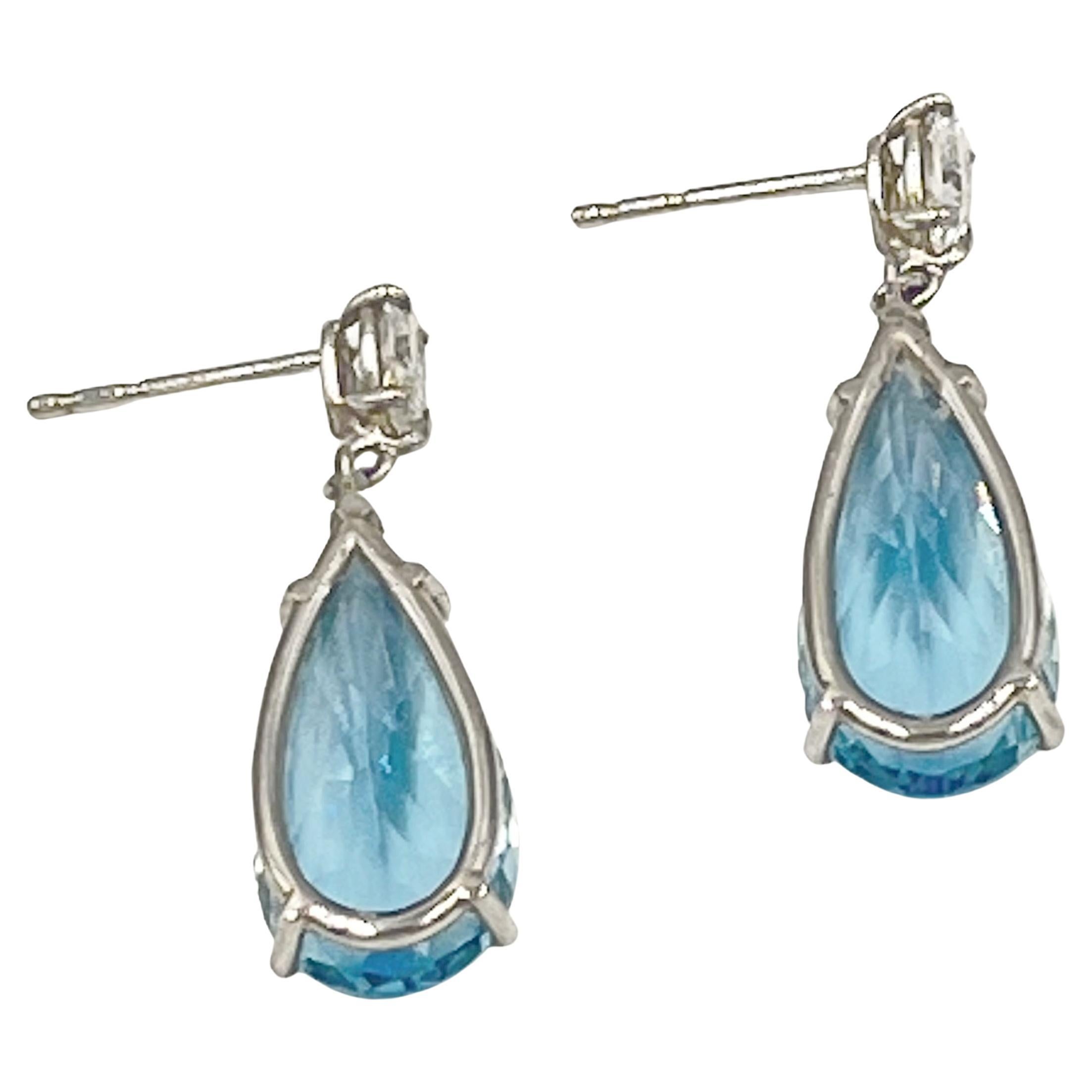 Aquamarine and diamond drop earrings, set in platinum.  Vibrant faceted, pear-shaped aquamarine drops are suspended from pear-shaped diamond surmounts.  Two aquamarines weighing 11.18 total carats and two diamonds weighing 0.63 total carats (F-G