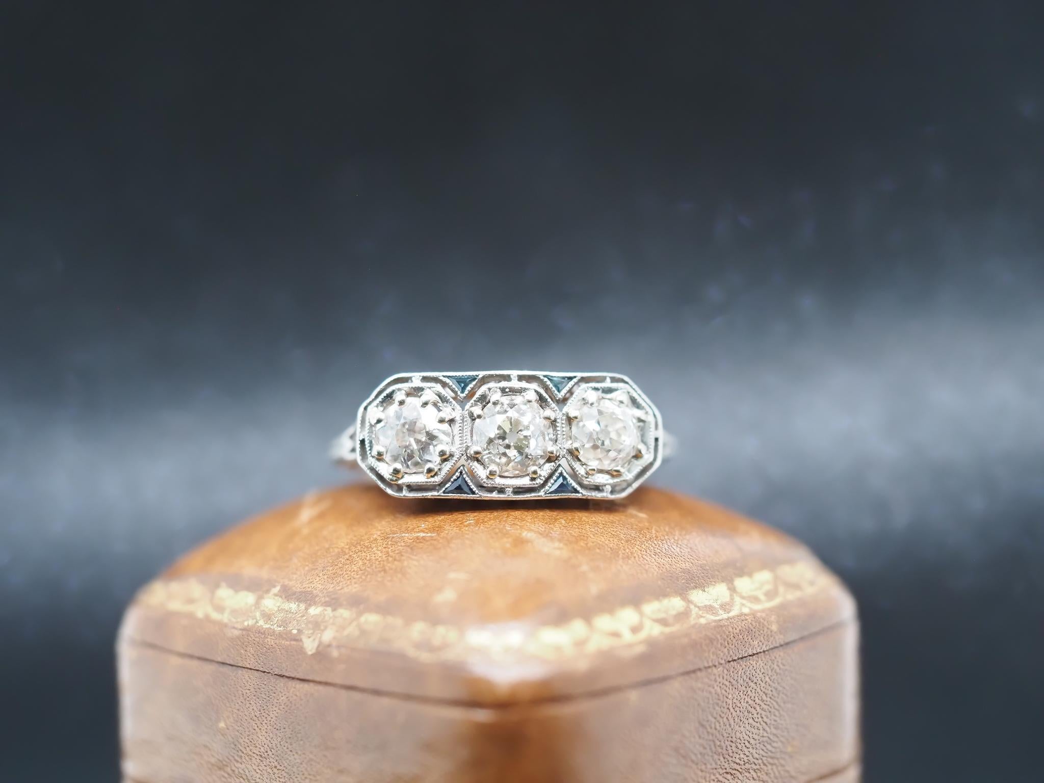 Year: 1920s
Item Details:
Ring Size: 8.25 (Sizable)
Metal Type: Platinum [Hallmarked, and Tested]
Weight: 3.6 grams
Diamond Details: 1.00ct total weight, Old European Brilliant, J/K Color, SI Clarity.
Side Stone Details: Natural Sapphires,