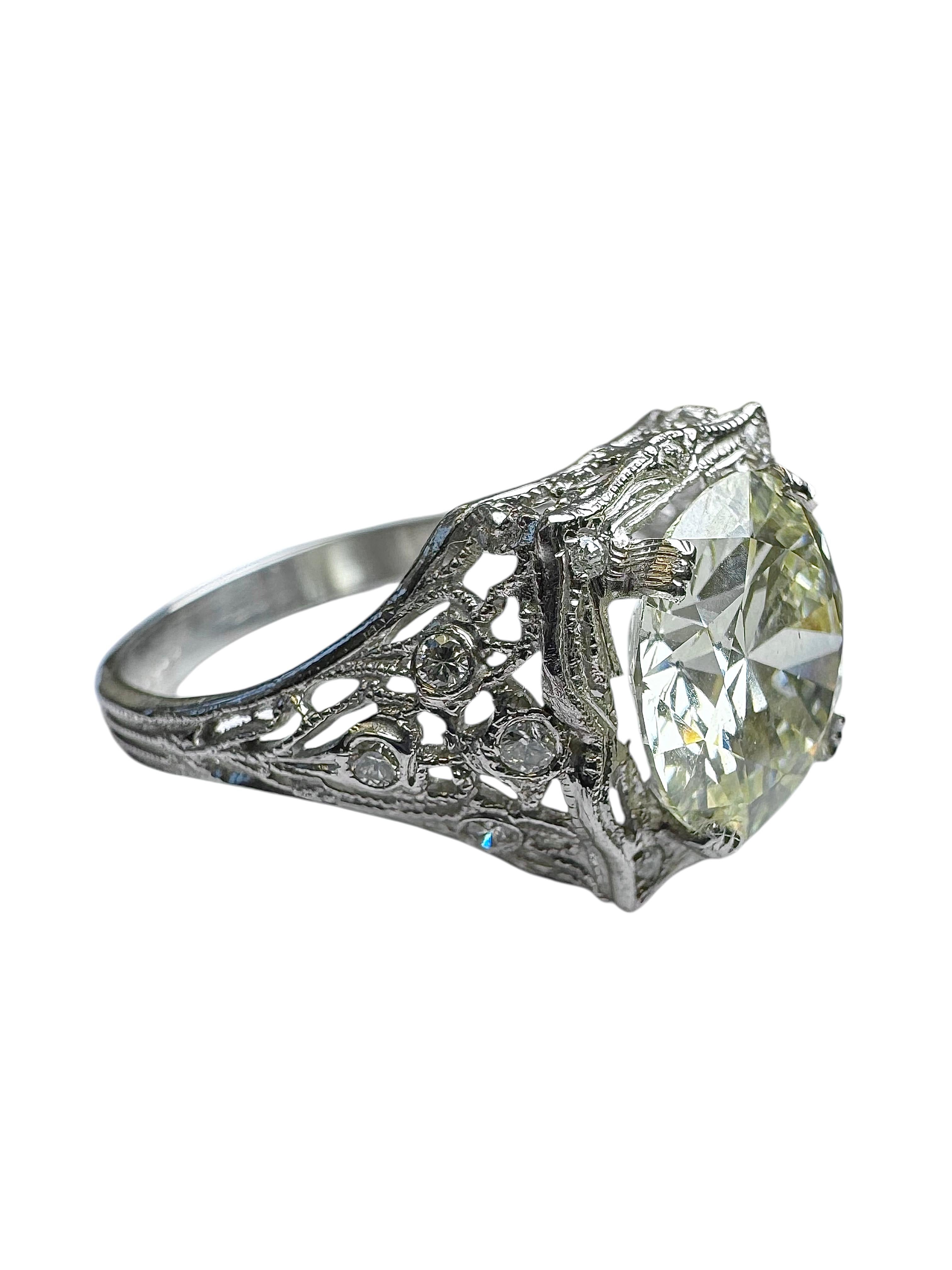 Magnifique bague en diamant de style Art déco, réalisée en platine avec un filigrane exquis et des détails gravés à la main. La pièce maîtresse est un impressionnant diamant de taille européenne ancienne pesant environ 3,42 carats, qui présente les