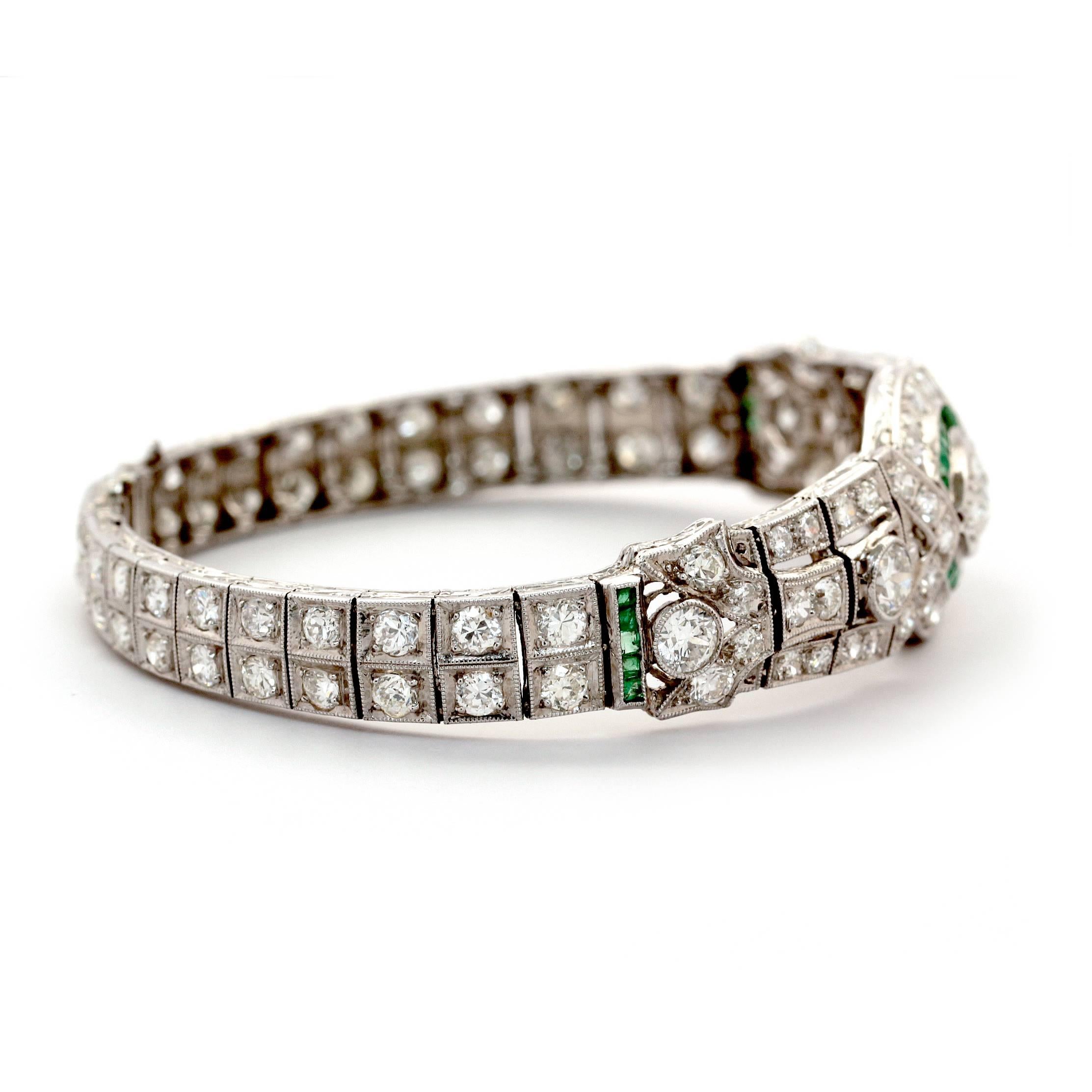 This stunning platinum Art Deco Bracelet has 62 round diamonds weighing approximately 5.50ct  and 28 square cut green Emeralds weighing approximately 10ct. 
beautiful details and articulated design.
Weights 15.9 grams.
It has a length of 17.9cm and