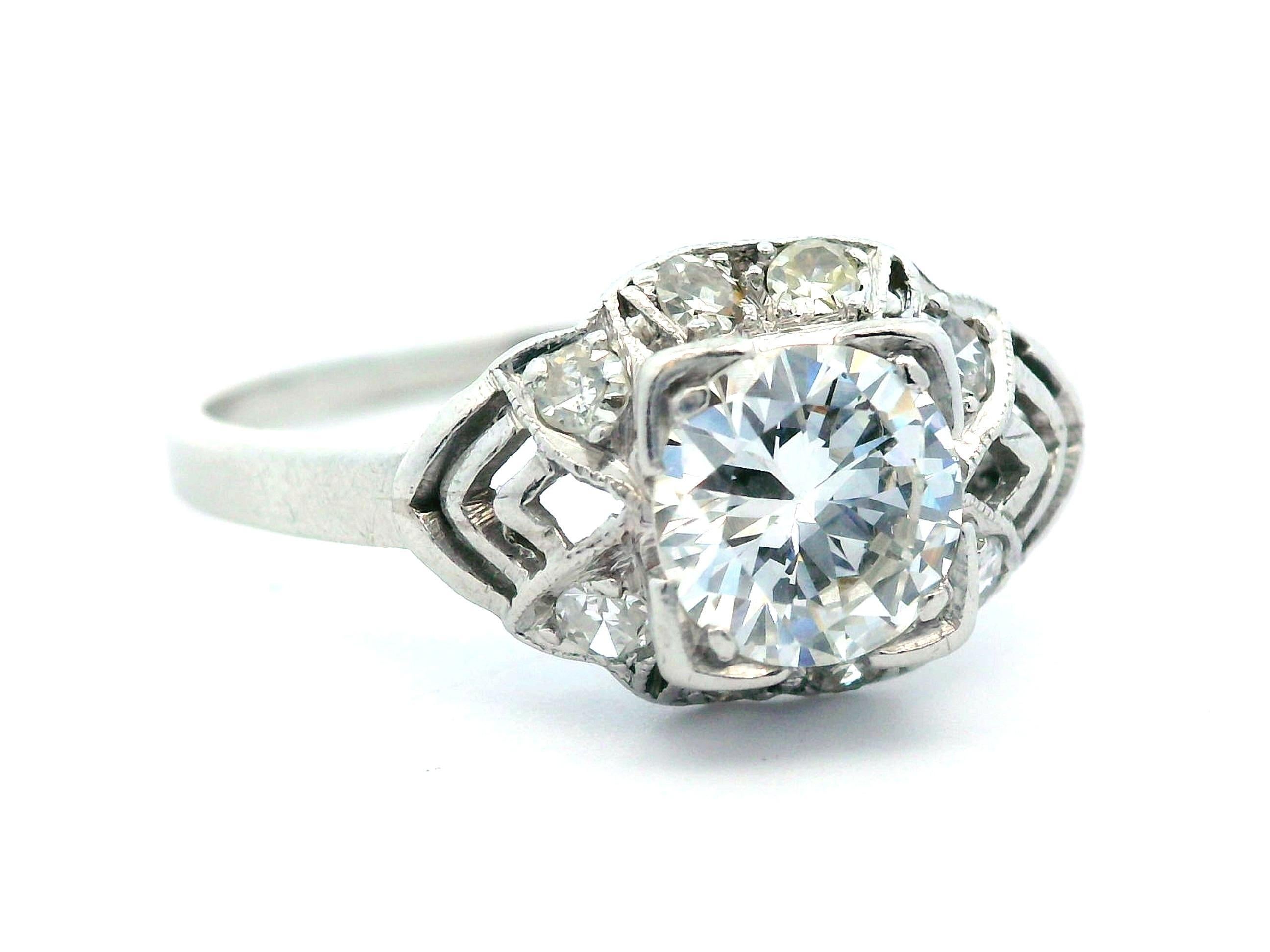 This incredible ring comes from the 1920 Art Deco period and features an incredible diamond. The Art Deco band is made in platinum and features a gorgeous filigree pattern that stands out compared to modern designs. The center stone is a round cut,
