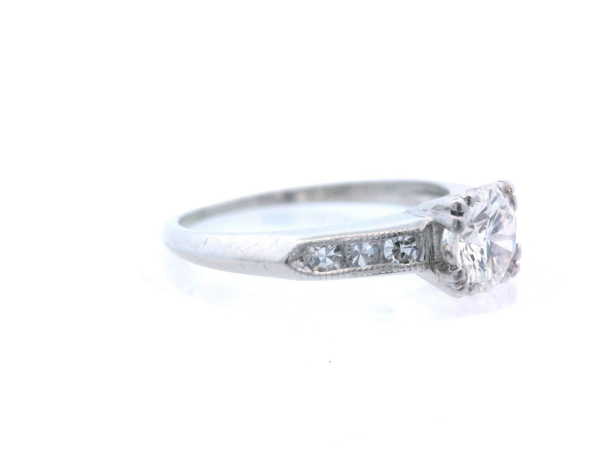 Questo splendido anello di fidanzamento con diamante risale al periodo Art Deco degli anni '30 ed è realizzato in platino. La pietra centrale è un eccezionale diamante da mezzo carato, di colore H e purezza VVS2, che brilla intensamente. Su ognuna