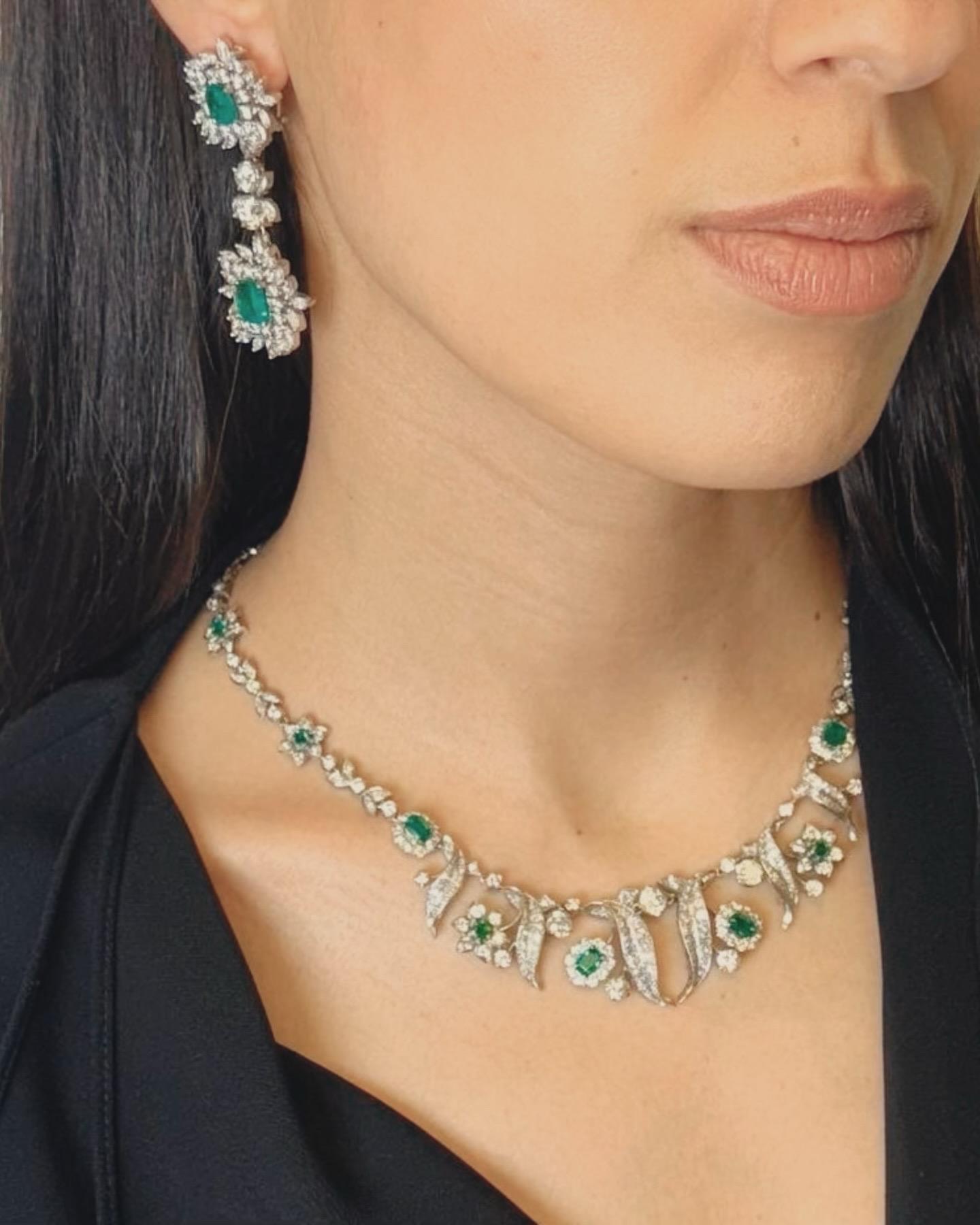 A breathtaking Art Deco platinum necklace featuring a lavish interplay of diamonds and vivid green emeralds in a botanical motif. This exquisitely crafted piece is set with five richly saturated Colombian emerald-cut emeralds, each framed by