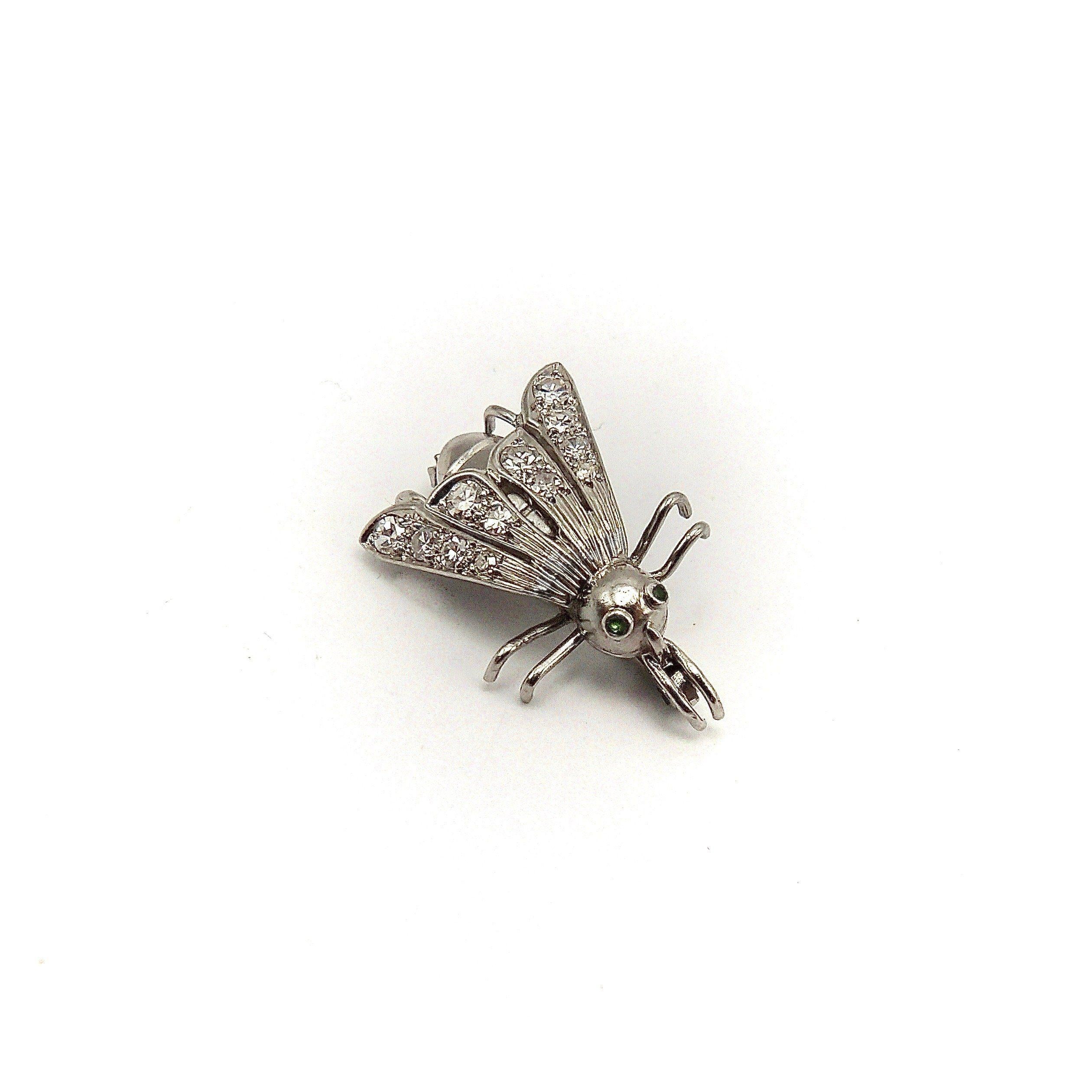 This is an impeccably crafted platinum fly pin from the Art Deco Era. You won’t want to swat this diamond and emerald encrusted fly pin away! The details to admire are many. The platinum body has six tiny legs and the wings have grooves that lead to