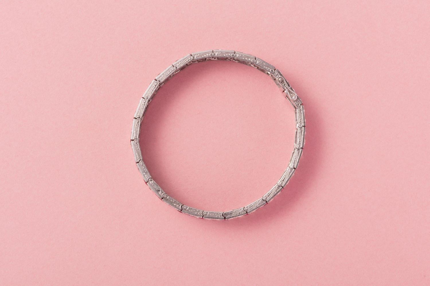 This exceptional platinum Art Deco bracelet has it all. It is pavé set with old-cut diamonds (app. 11.52 carats in total). The hallmark of Art Deco design, a striking geometric pattern, takes form as a zigzag line of unheated, baguette-cut, deep red