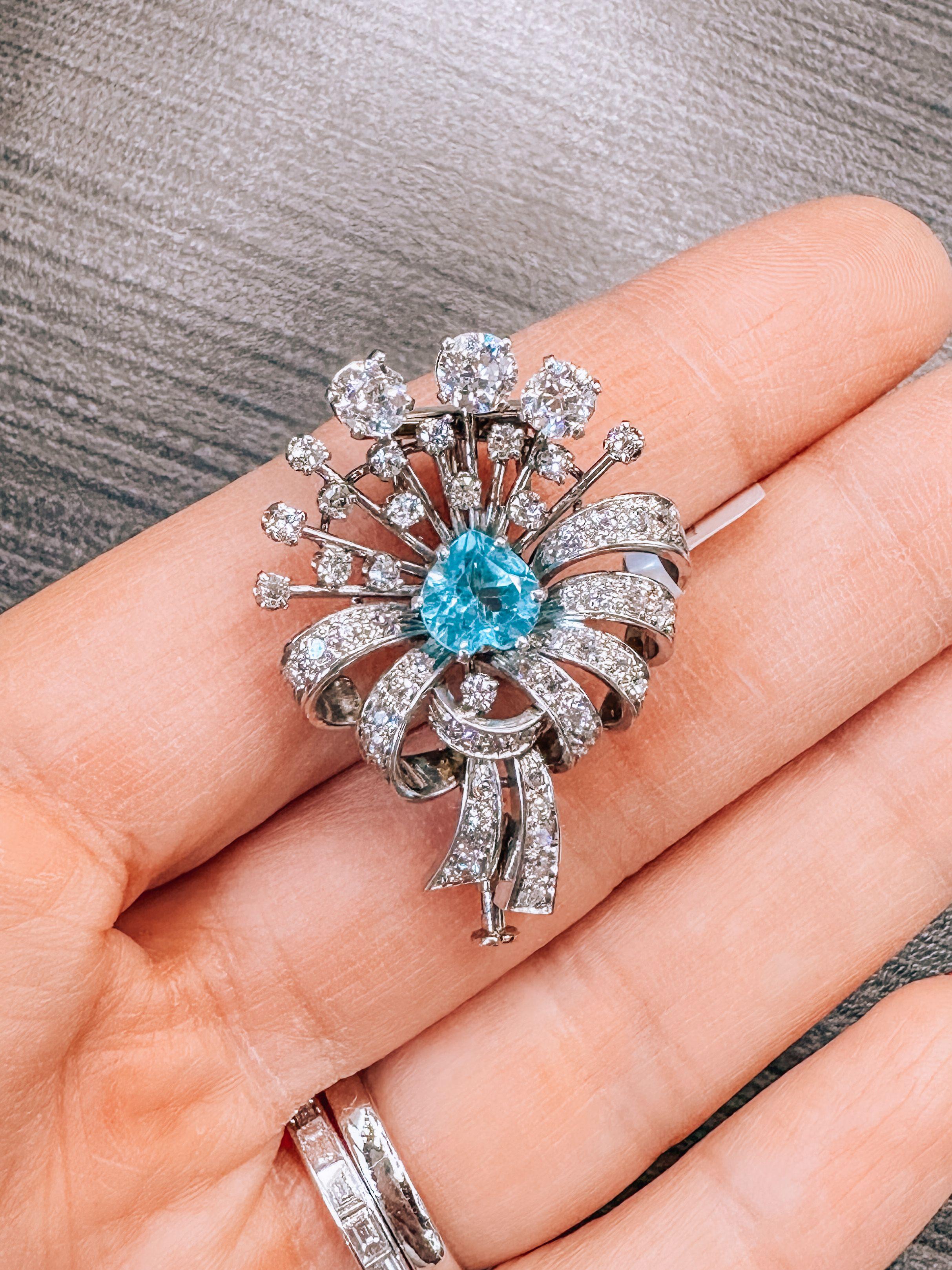 Just about 1 inch in length this brooch is a lovely jewel from the Art Deco era. Encrusted with old cut diamonds and mounted with a light aquamarine in the center you will love this beauty and will wear it for every occasion. 
We love that it is